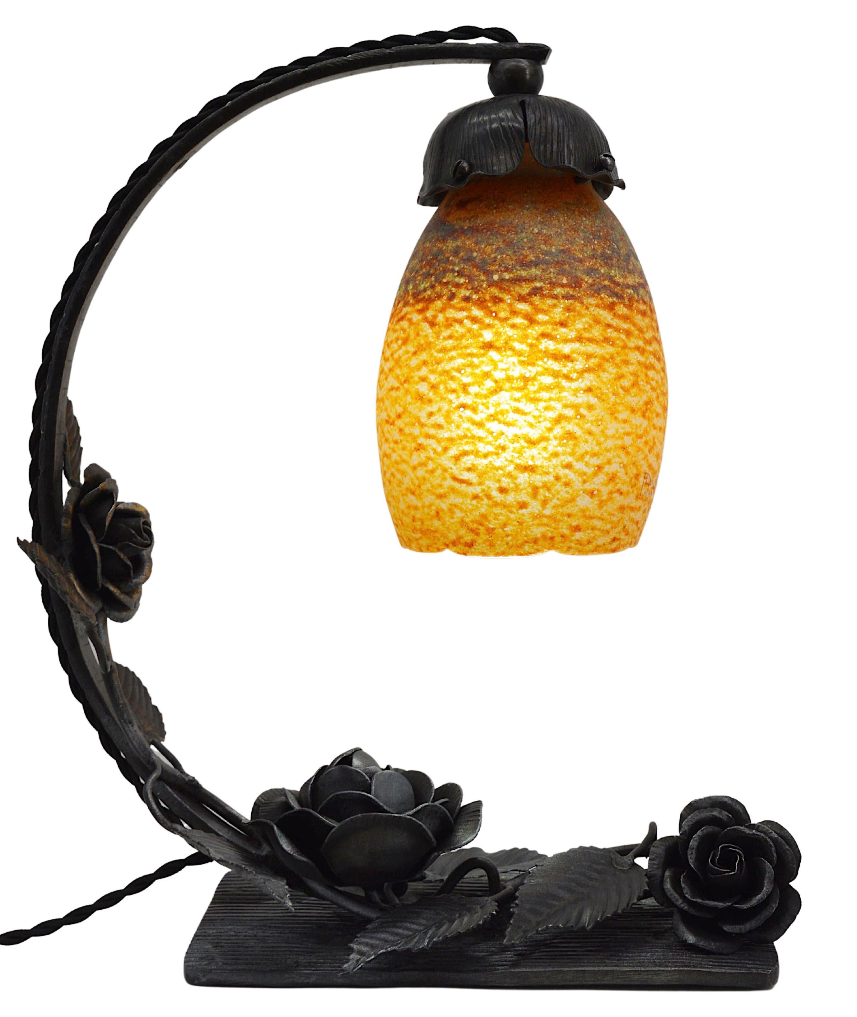 French Art Deco table lamp by Andre Delatte (Jarville, Nancy), France, Late 1920s. Blown double glass shade by Delatte hung at its wrought-iron base decorated with a rosebush. Height : 12.6