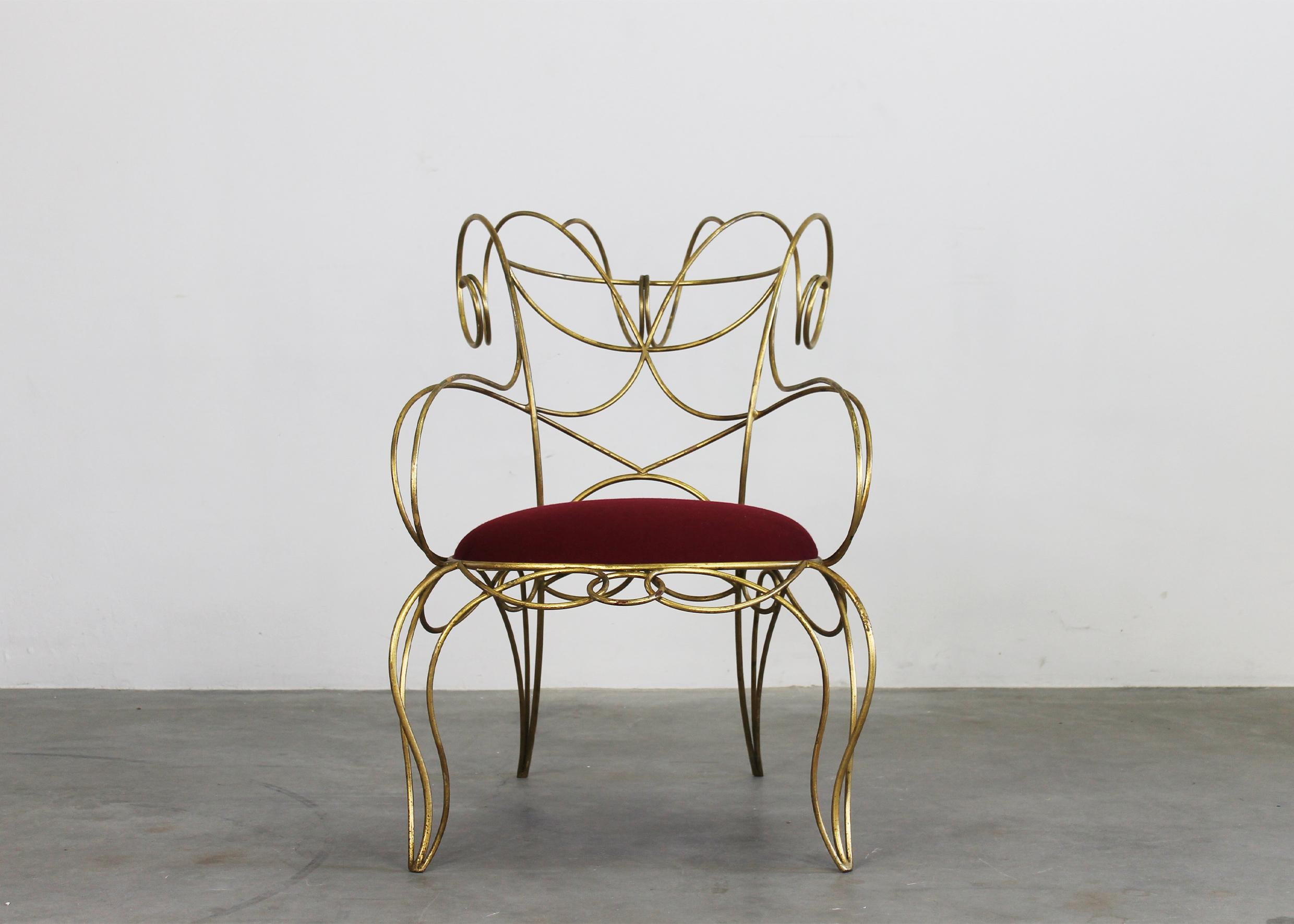 Ram armchair with structure in gold-leaf lacquered iron rod, plywood seat in padded red fabric, designed by Andrè Dubreuil and produced by Ceccotti. 

The Ram armchair is an example of a sculptural seat realized by a 10/12 mm iron rod twisted and