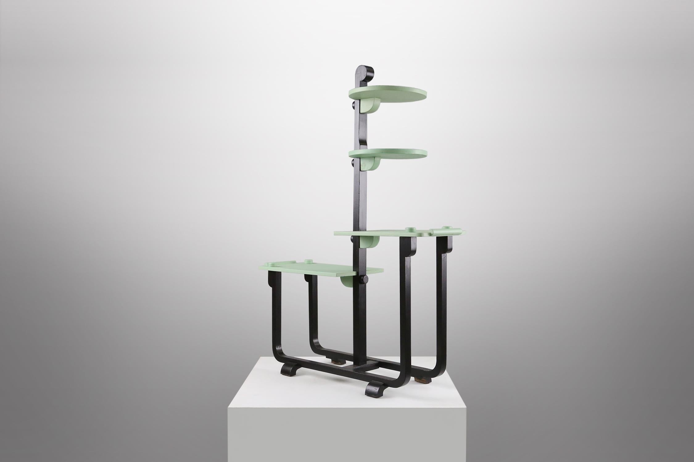 
This flower stand designed by Adré Groult around 1925 is made of black lacquered wood with green shelves. It is a elegant and modern piece of modernism and Art Deco.

André Groult (1884-1966) was a French decorator and furniture designer, and one