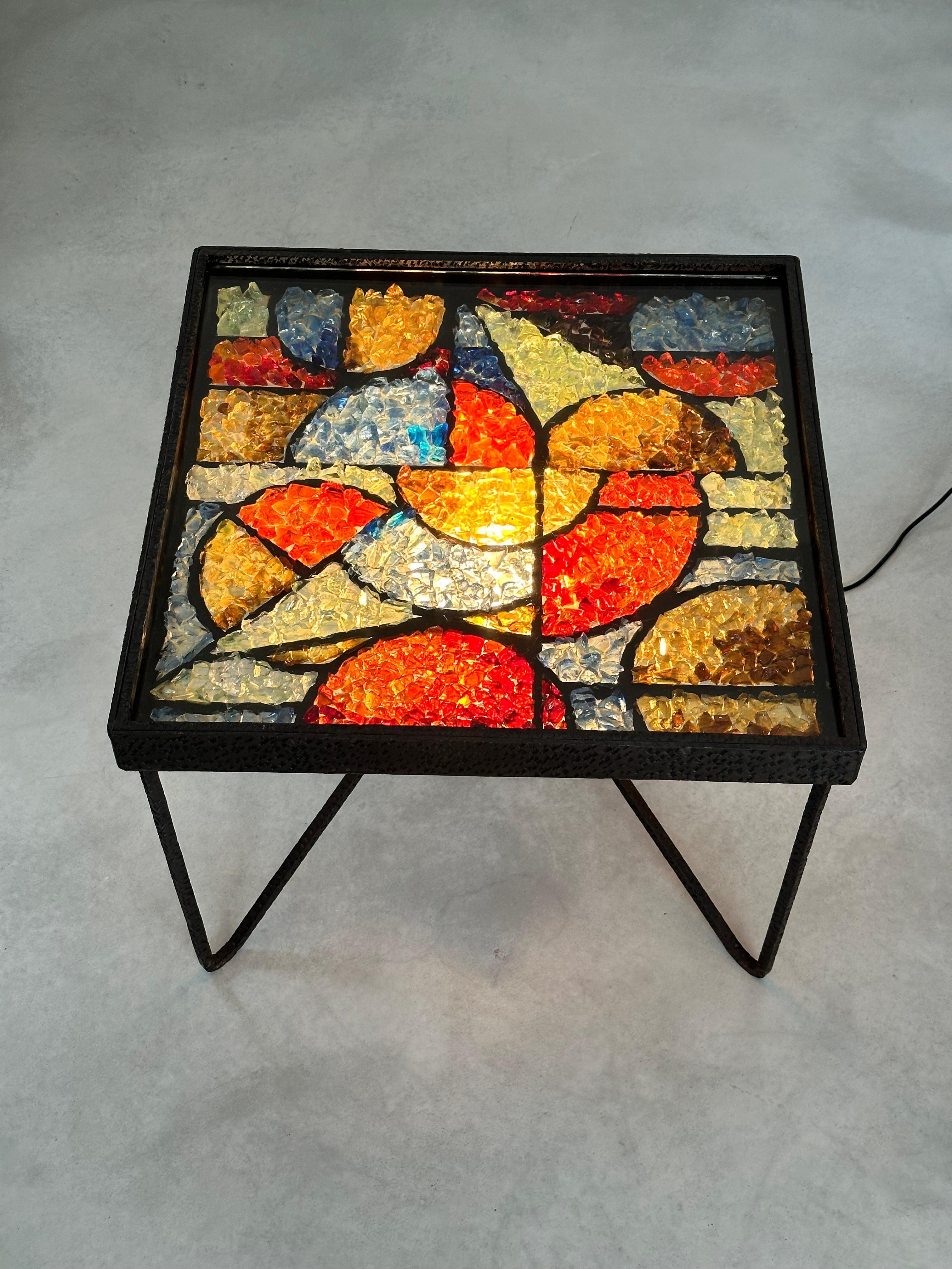 Exceptionnelle table basse lumineuse de l'architecte André Kulesza, en fer forgé martelé et cristaux de verre polychrome. 

Les fragments de cristaux de verre ont été soigneusement sélectionnés et combinés harmonieusement pour représenter un motif