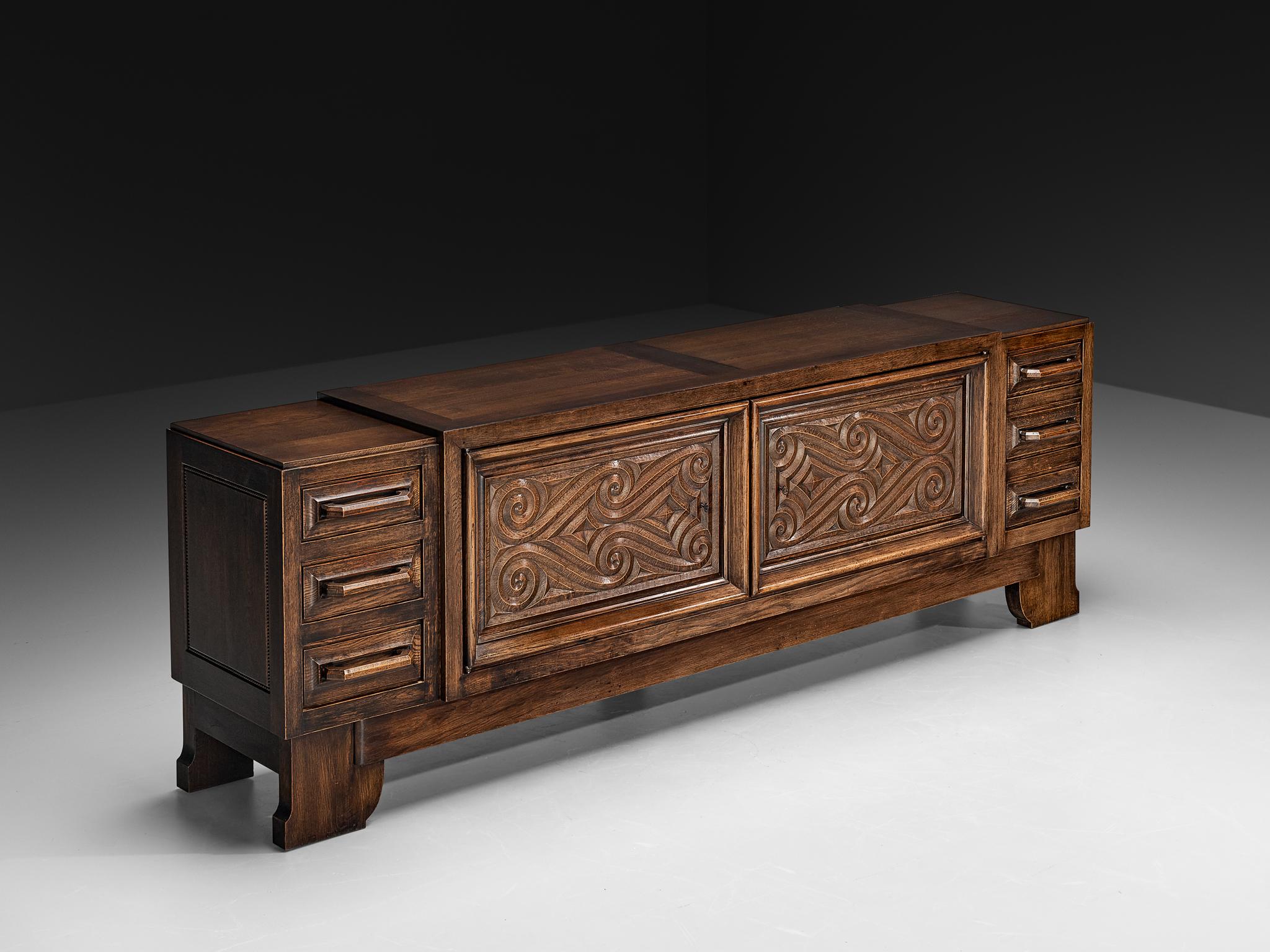 André Le Picard, sideboard, solid oak, France, 1930s

Designed by the Frenchman André Le Picard, this sideboard is a testament to exquisite craftsmanship and profound artistry. The piece can be interpreted within the context of the Seiz Breur art