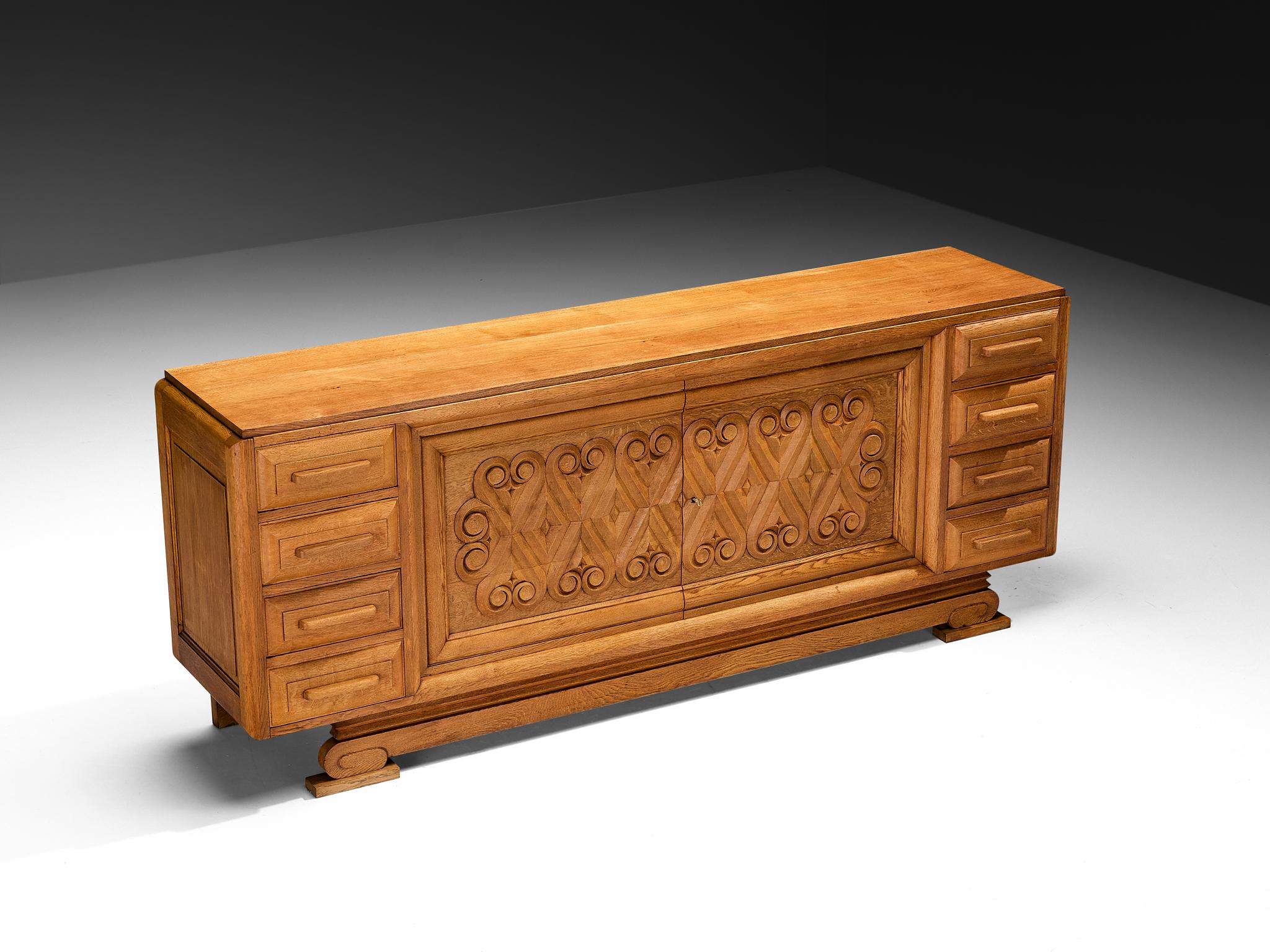André Le Picard, sideboard, solid oak, France, 1930s

Designed by the Frenchman André Le Picard, this sideboard is a testament to exquisite craftsmanship and profound artistry. The piece can be interpreted within the context of the Seiz Breur art
