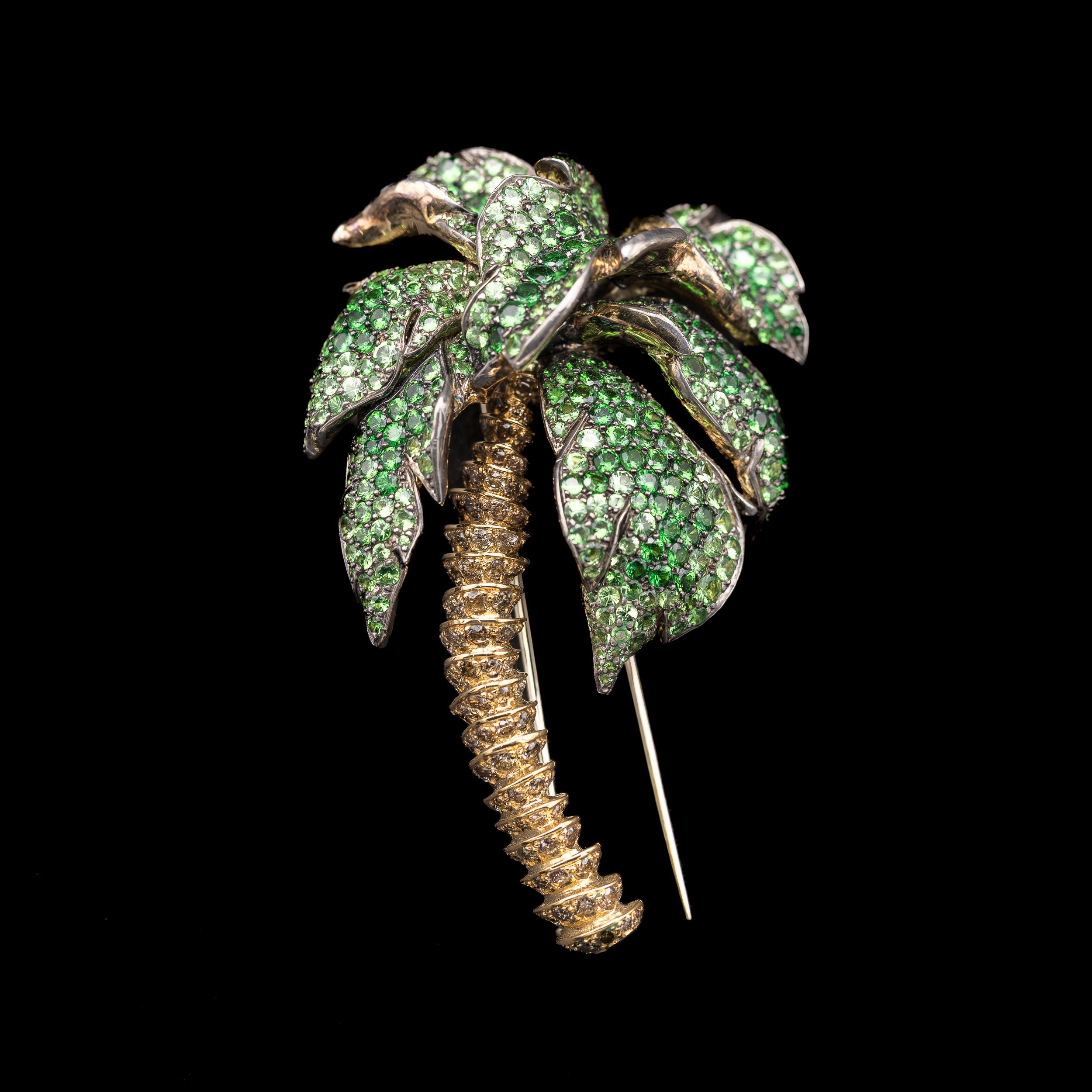 ANDRE MARCHA Palm green garnet and fancy colored yellow and brown diamond pin brooch in 18kt yellow gold and sterling silver, accompanied by maker’s travel pouch in gray suede, Lebanon, 2000s. From the Lebanese brand’s Naturalis collection and