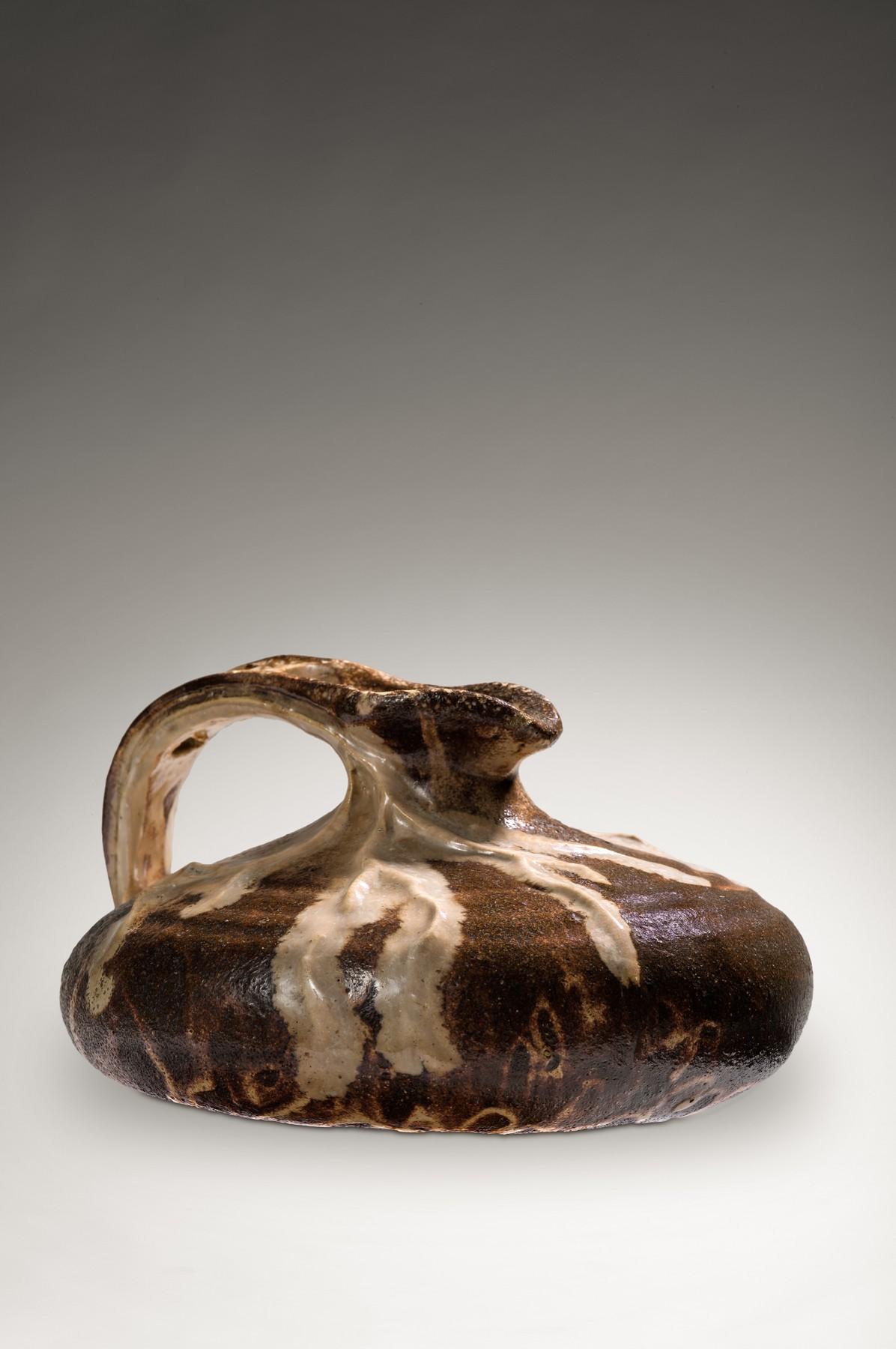 André Metthey, author of this masterpiece of stoneware, is not in his first ceramic experiment when he produces this unpublished object. The pitcher relatively flattened, consists of a curved, circular belly, ending in a flared neck with a narrow