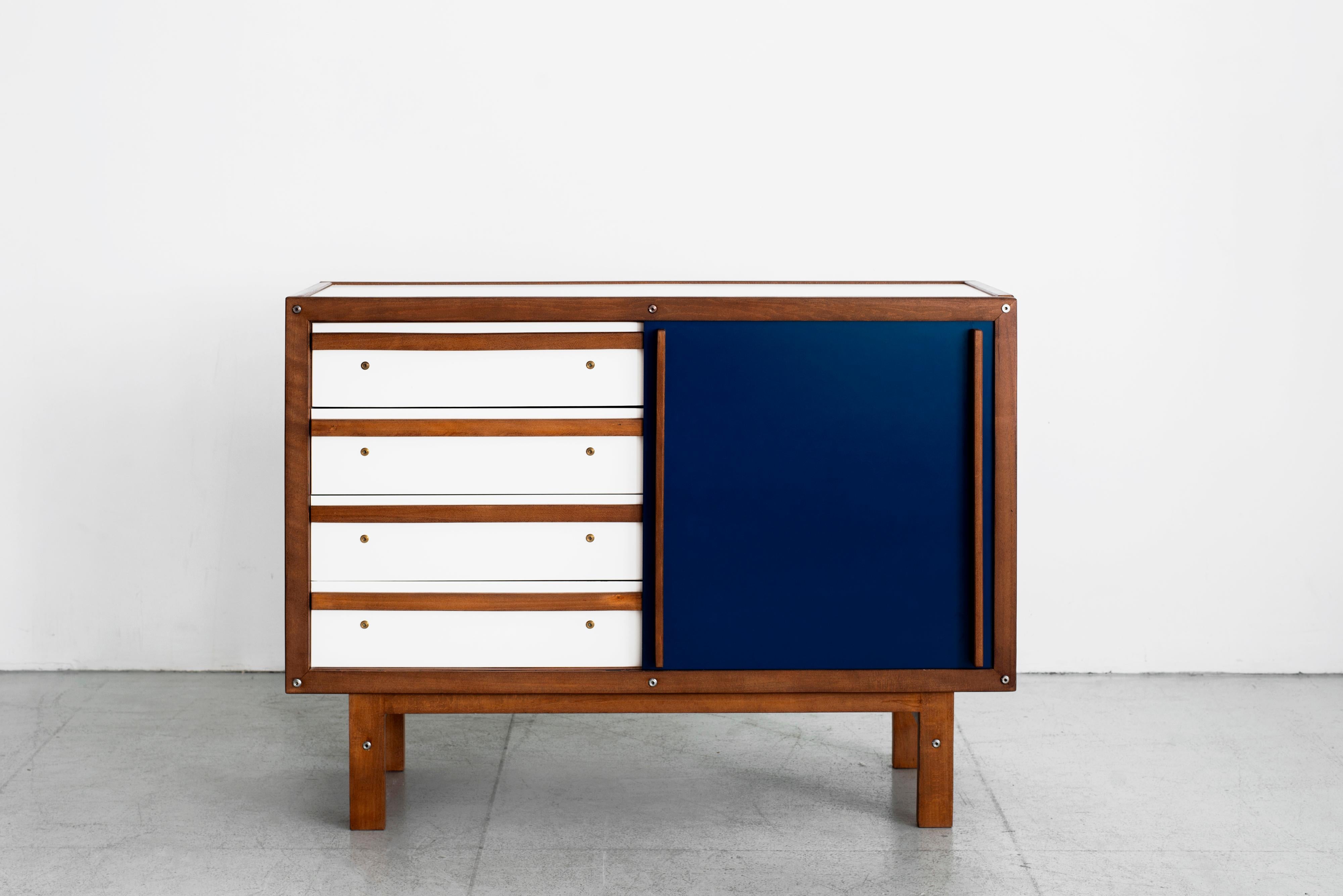 Rare dresser cabinet by French cabinetmaker Andre Sornay. 
Cabinet has four white drawers and one blue sliding door. 
Oak trim throughout and oak handle. 
Sliding door revealing drawers on one side and open shelving on the other.
Black also