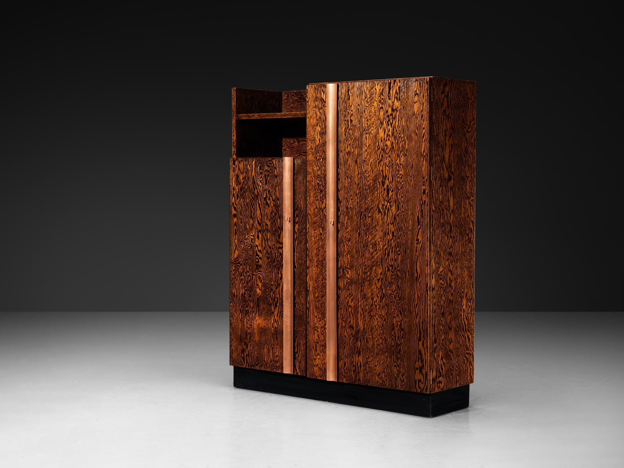 André Sornay, grande armadio, pino dell'Oregon, rame, Francia, circa 1934

Questo grande mobile, progettato da André Sornay intorno al 1934, esemplifica il suo approccio idiosincratico al design. Realizzato in pino dell'Oregon, un materiale che