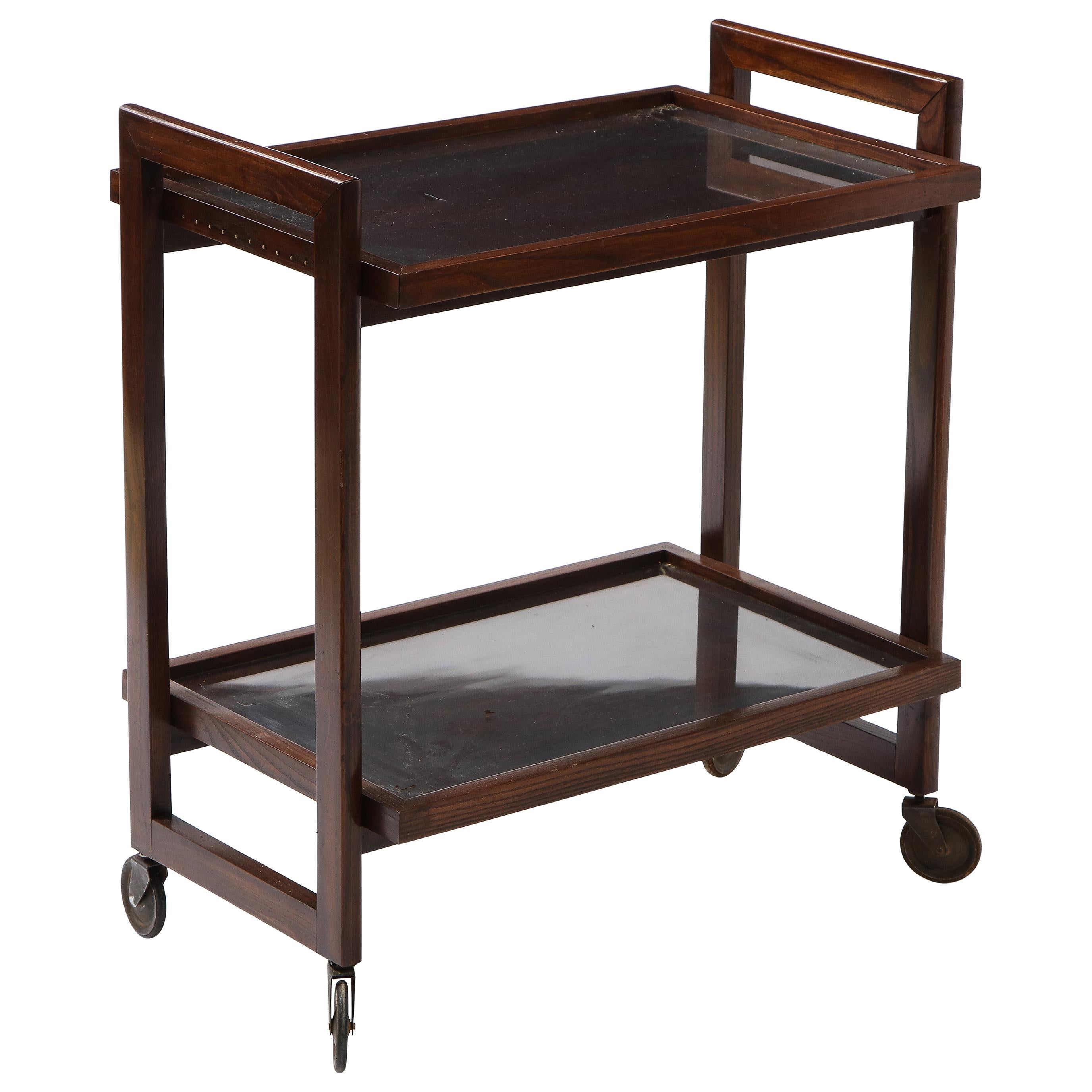 Elegant Andre Sornay bar cart in darkened Oregon pine on steel and rubber casters, each tray has an inset glass piece protecting the wood for use. The sides have a discreet line of embedded copper nails, the classic signature flourish of Sornay.