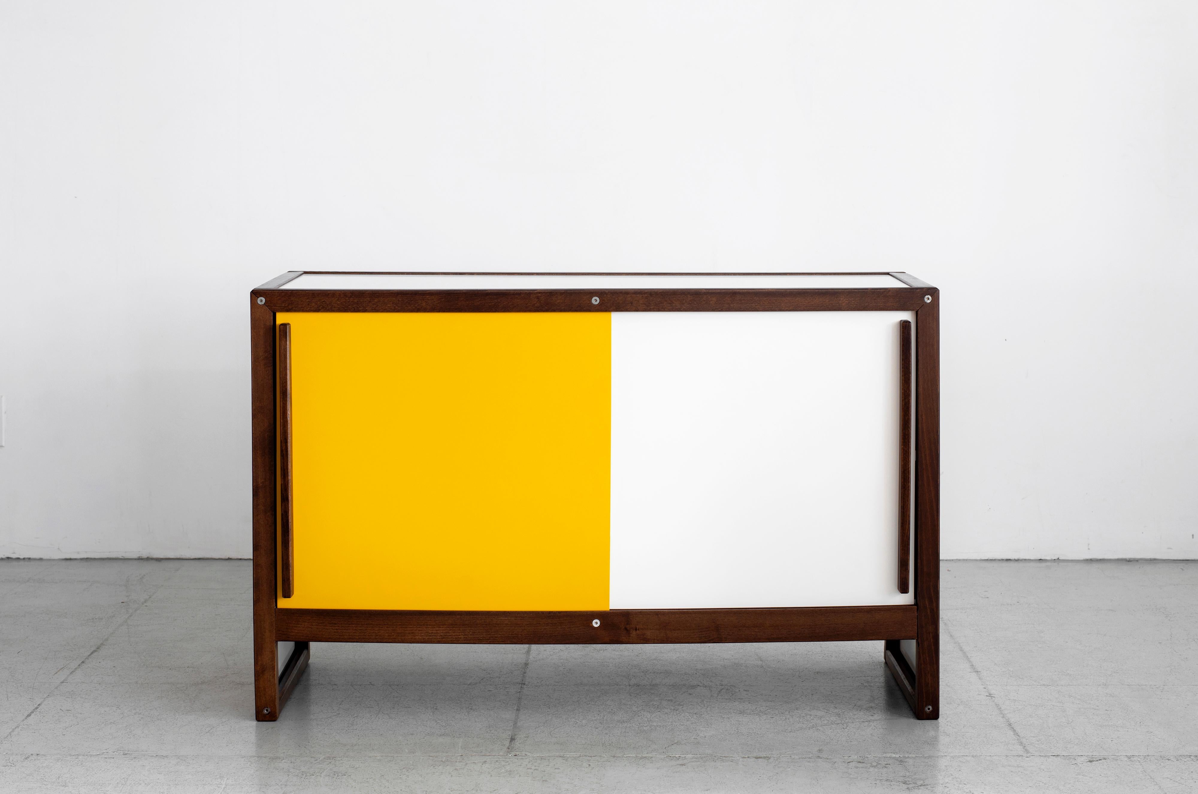 Rare sideboard by French cabinetmaker André Sornay. Cabinet features bright yellow and white sliding doors on both sides framed in French oak.
Fantastic oak handles and plinth base.
  