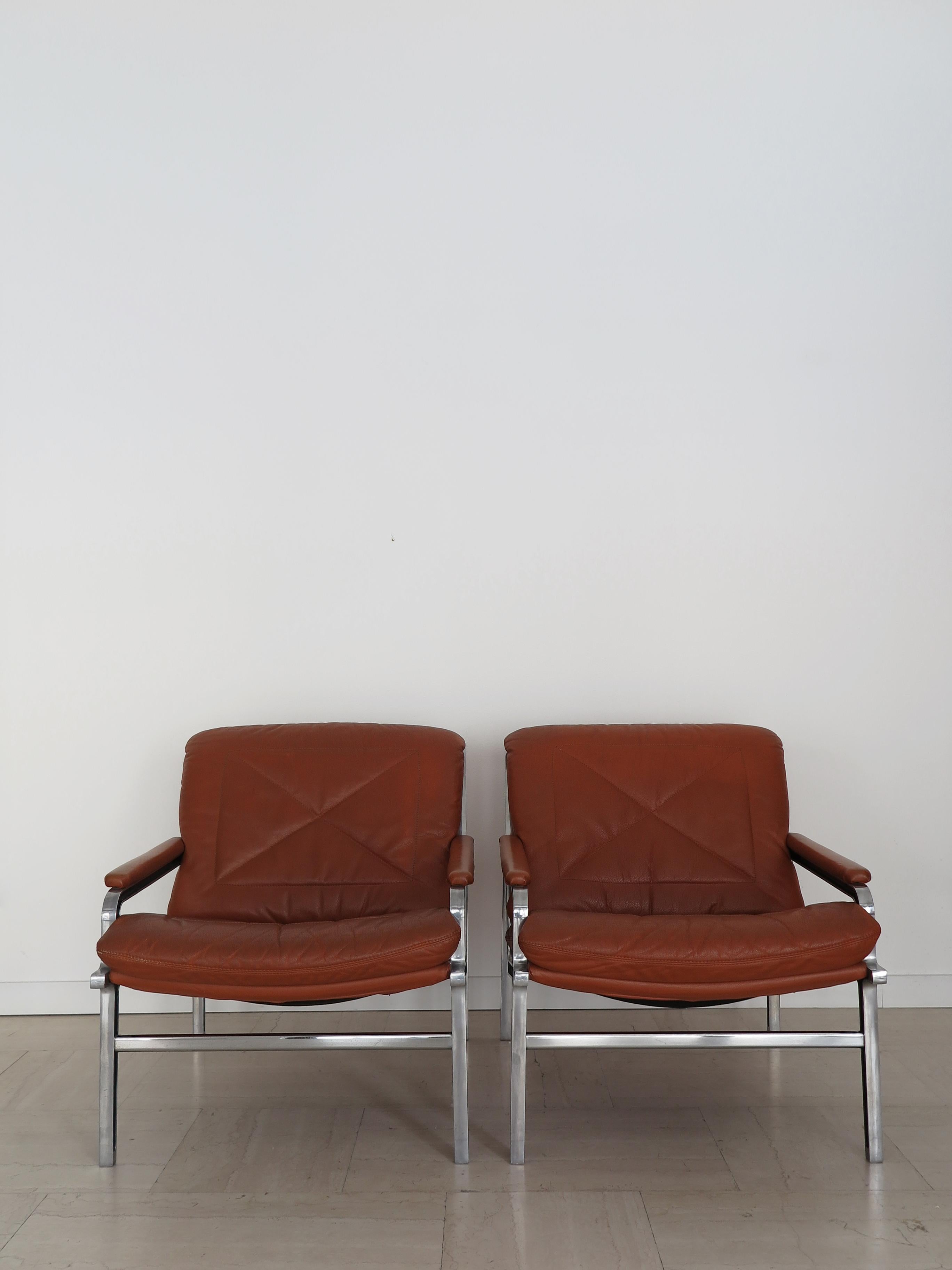 Set of two midcentury armchairs model ‘Aluline’ designed by Andre’ Vandenbeuck and manufactured by Strassle International with die-cast aluminium frame partially painted black and upholstery covered in orange-brown leather, Swiss production