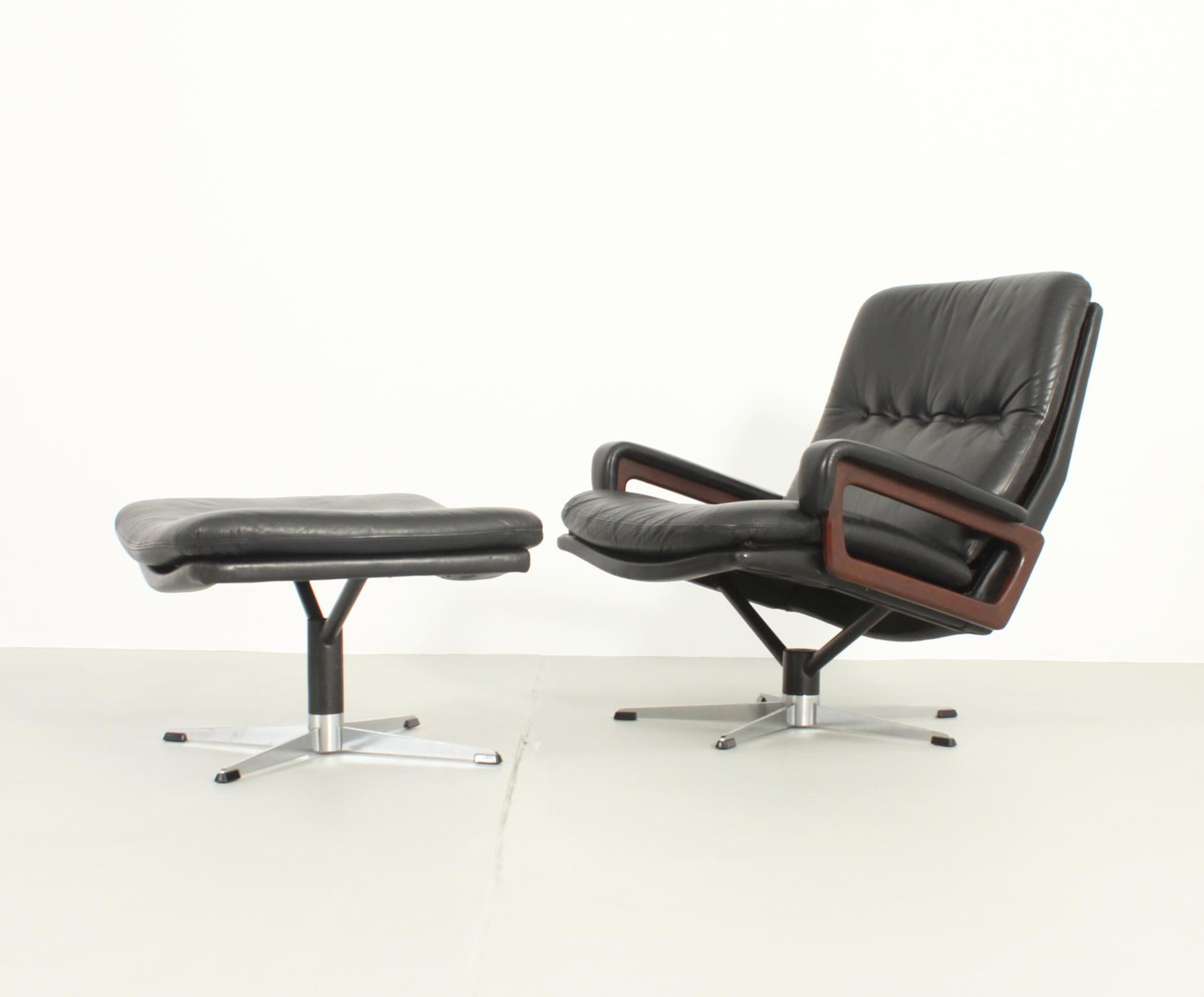 King lounge chair with ottoman designed by André Vandenbeuck in 1960's and produced by Arflex, Italy. Swivel lounge chair and ottoman upholstered in leather, wood arms and polished steel base.