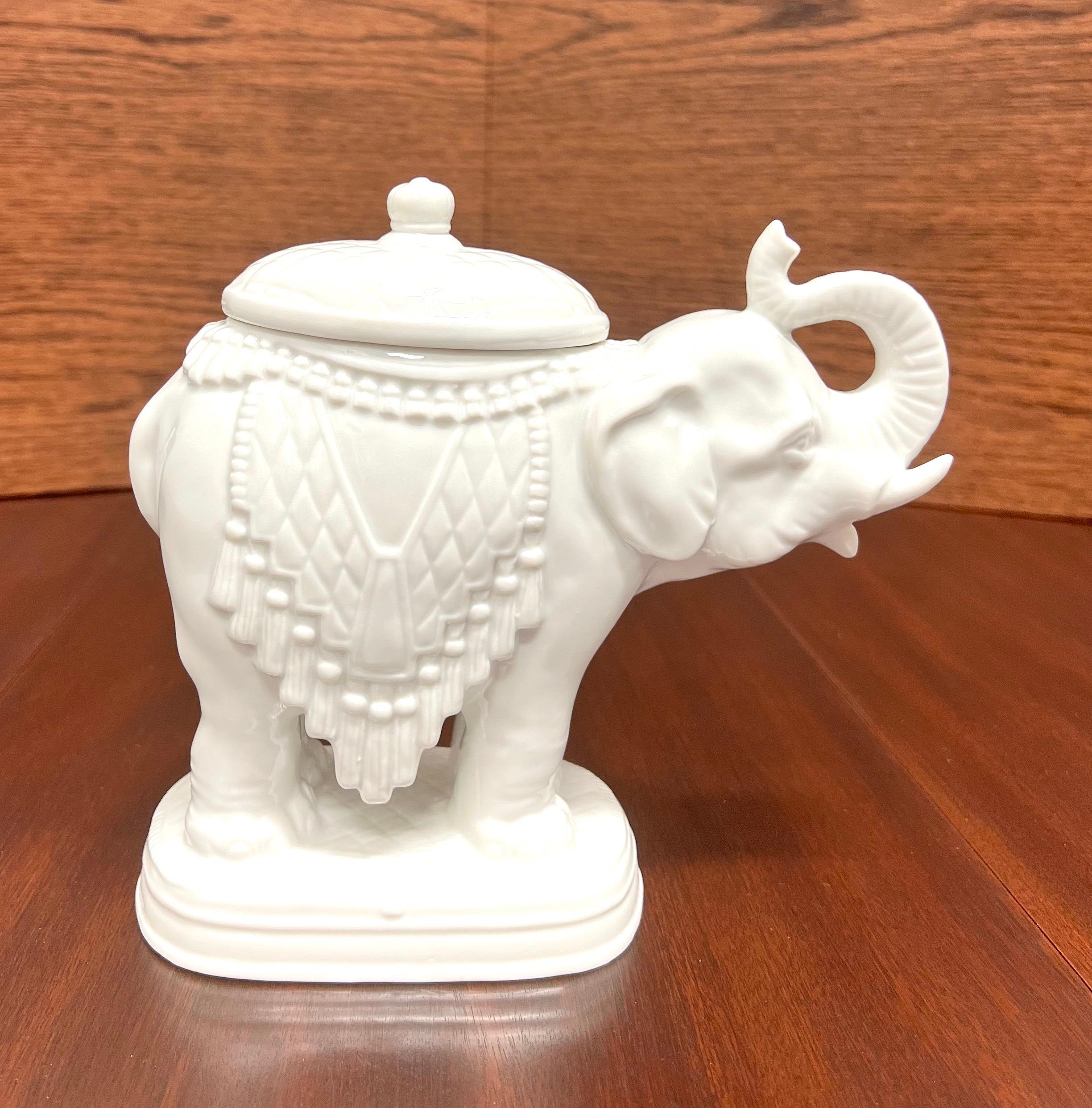 An Asian style candy dish in the shape of an elephant by Andrea by Sadek. Hand painted, white in color glazed porcelain of an Asian elephant with an oval shaped lid. Made in Japan, in the late 20th Century.

Measures:  3.5w 8d 7.5h, Weighs