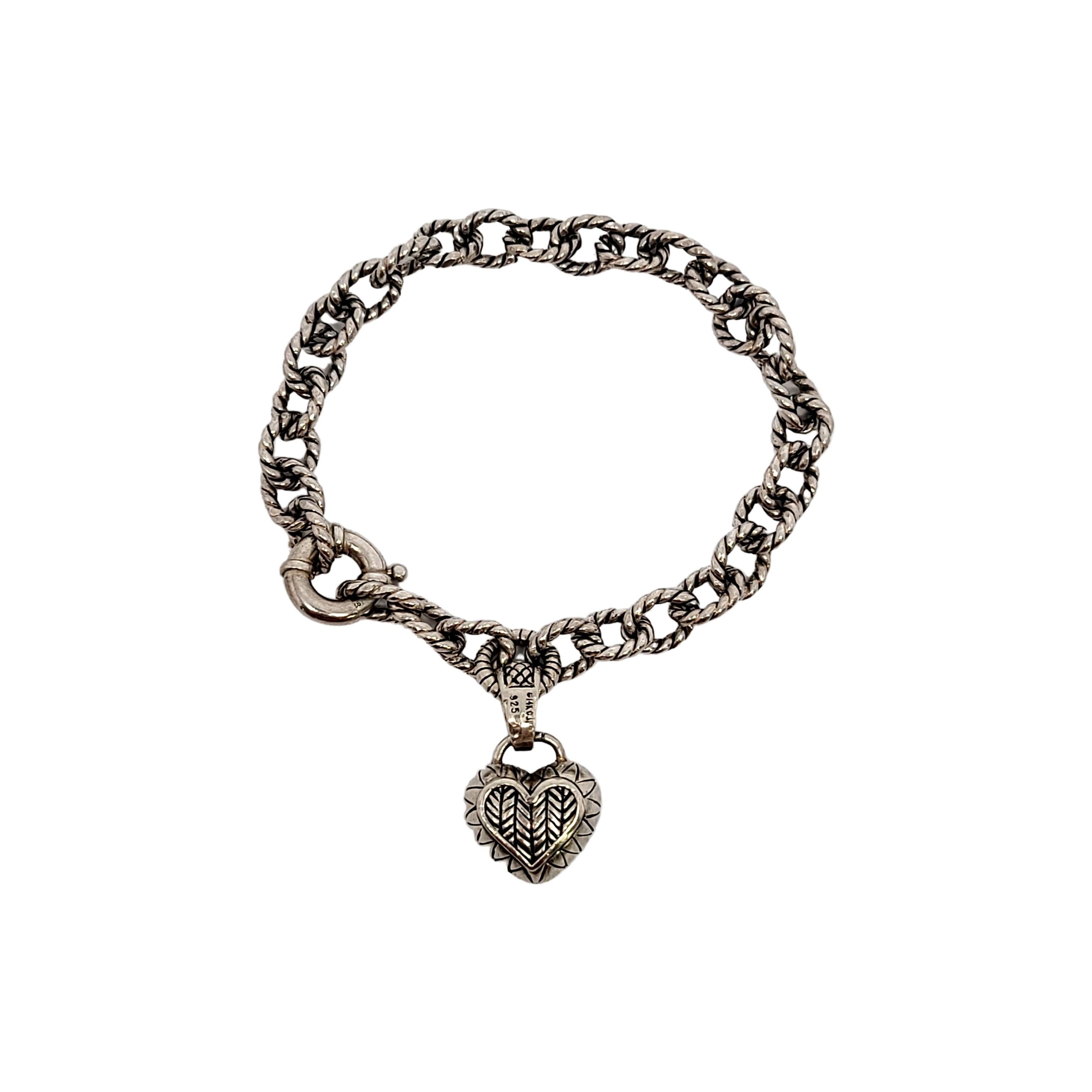 Sterling silver textured link charm bracelet with sterling silver heart dangle with 14K yellow gold and diamond accents by designer Andrea Candela of Spain.

This beautiful piece features rope textured links. The heart dangle features a chevron