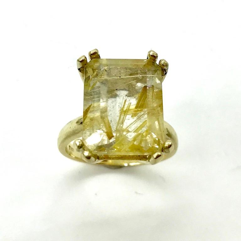 An absolutely Stunning cocktail ring featuring a 11 carat emerald cut golden rutilated quartz from Brazil. This stunning stone is 12 x 16mm in size and has rutile needles through the quartz that create sparkle, glamour and making it 100% unique as