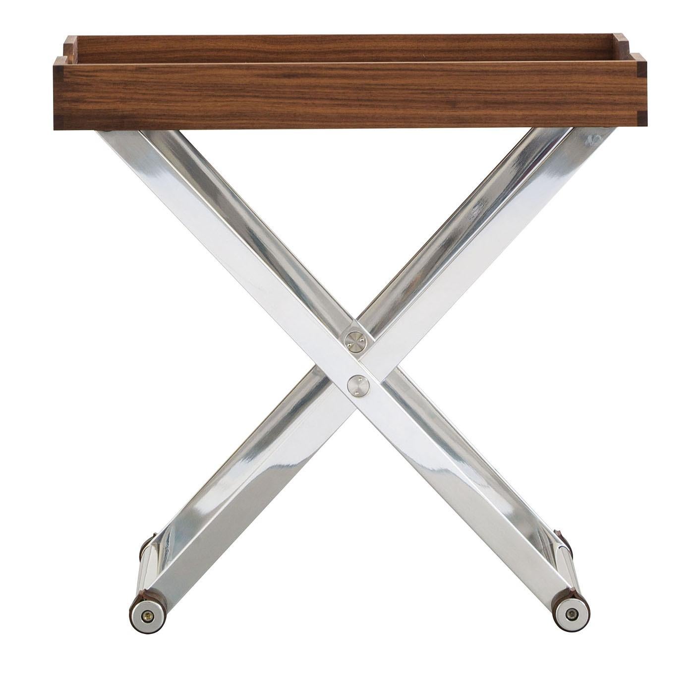 Ce plateau de service portable revisité est fabriqué en bois de noyer noir. La structure X est à la fois légère et durable, fabriquée en aluminium brossé et poli avec un traitement anticorodal. Des articulations en acier inoxydable et des anneaux de
