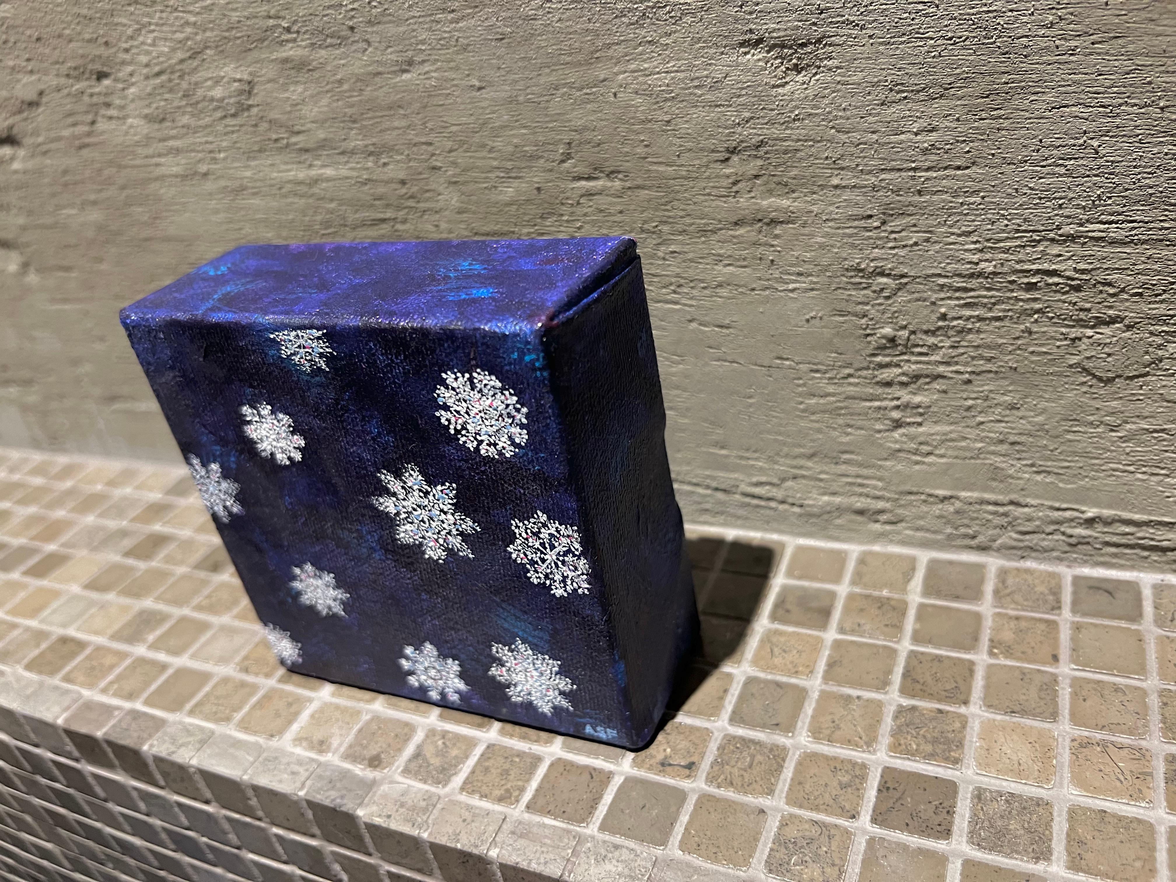 So little with so much to say. Discover the charm of this petite painting that speaks volumes. Intricate snowflakes glisten softly against a serene winter night sky. It's beauty lies in the highly delicate details within each unique snowflake. Using