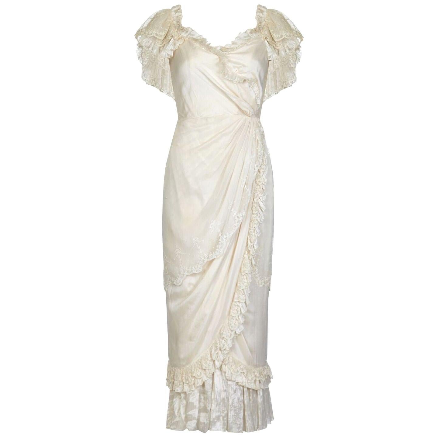 This exquisite Andrea Wilkin 1970s fantasy bridal gown in soft ivory exudes femininity and is in wonderful condition. Layers of silk fabric are beautifully arranged to create the classical romantic look reminiscent of the Edwardian era for which