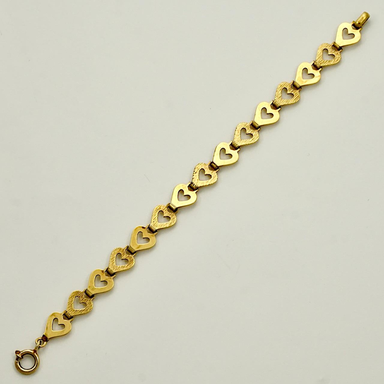 Andreas Daub propose un magnifique bracelet plaqué or, avec des maillons texturés et brillants en forme de cœur ouvert. Longueur approximative de 19,5 cm / 7,6 pouces et largeur de 1 cm / 0,39 pouce. Le bracelet présente des rayures, comme on peut