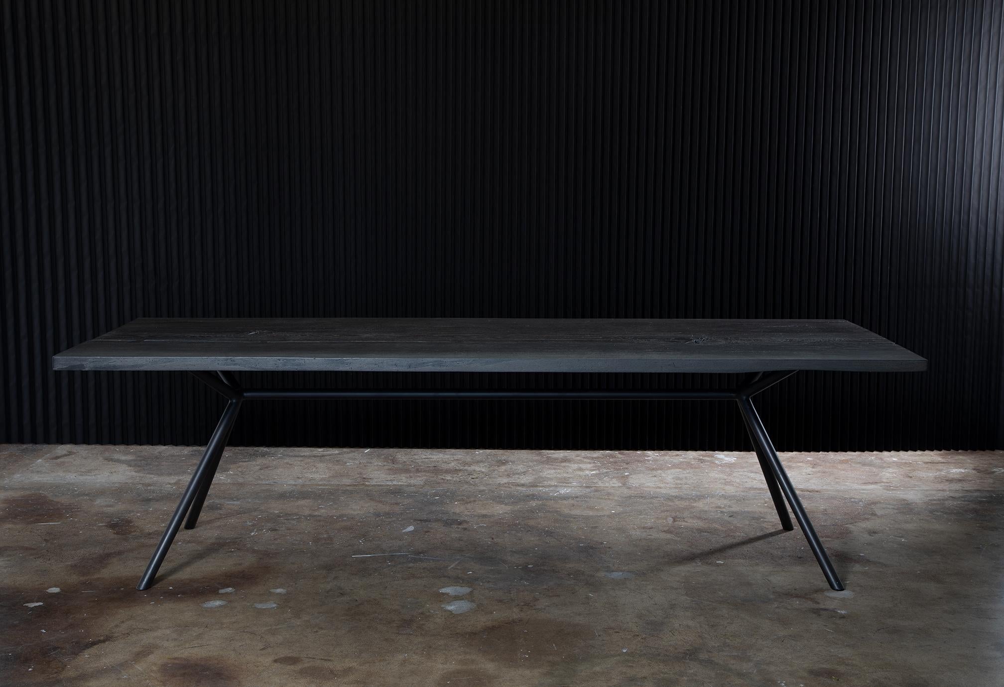 Inspired by Nicolas Andreas Taralis' wrapping and asymmetrical tailoring, the Andreas Dining Table has a dark edge to its minimal form. Sharp angles are in concert with ever-flowing lines, taking the eye beyond the table’s physical structure. The