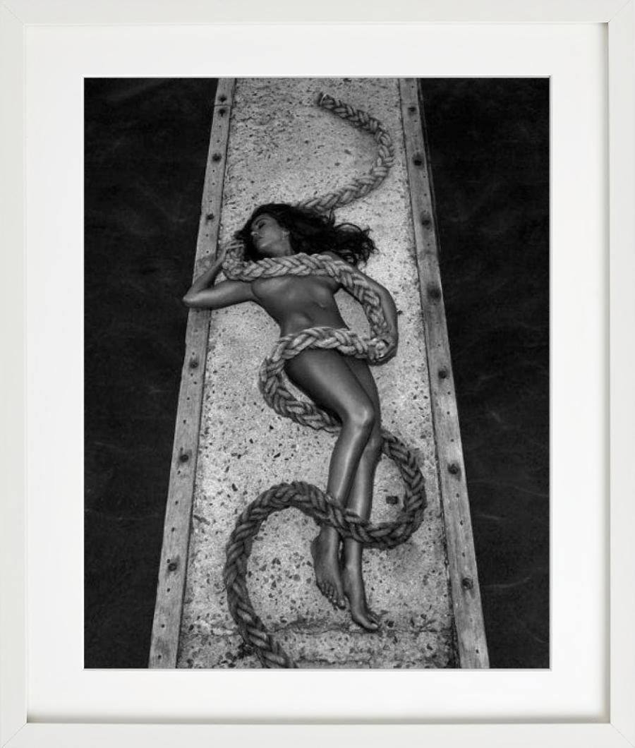 Desnudo en blanco y negro de la actriz Sabrina Ferilli en un embarcadero con una cuerda, fotografiado por Andreas H. Bitesnich y publicado en su libro 