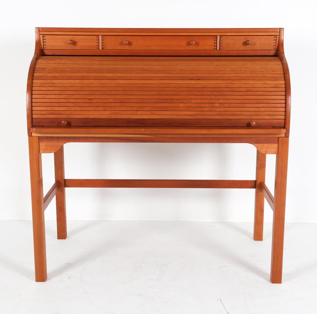 This beautiful teak desk was designed by Andreas Hansen for Hadsten Traeindustri sometime in the 1970's. The solid teak wood has a lovely warm tone with distinctive grains visible throughout. 

The roll top comes up to reveal the desk within, where