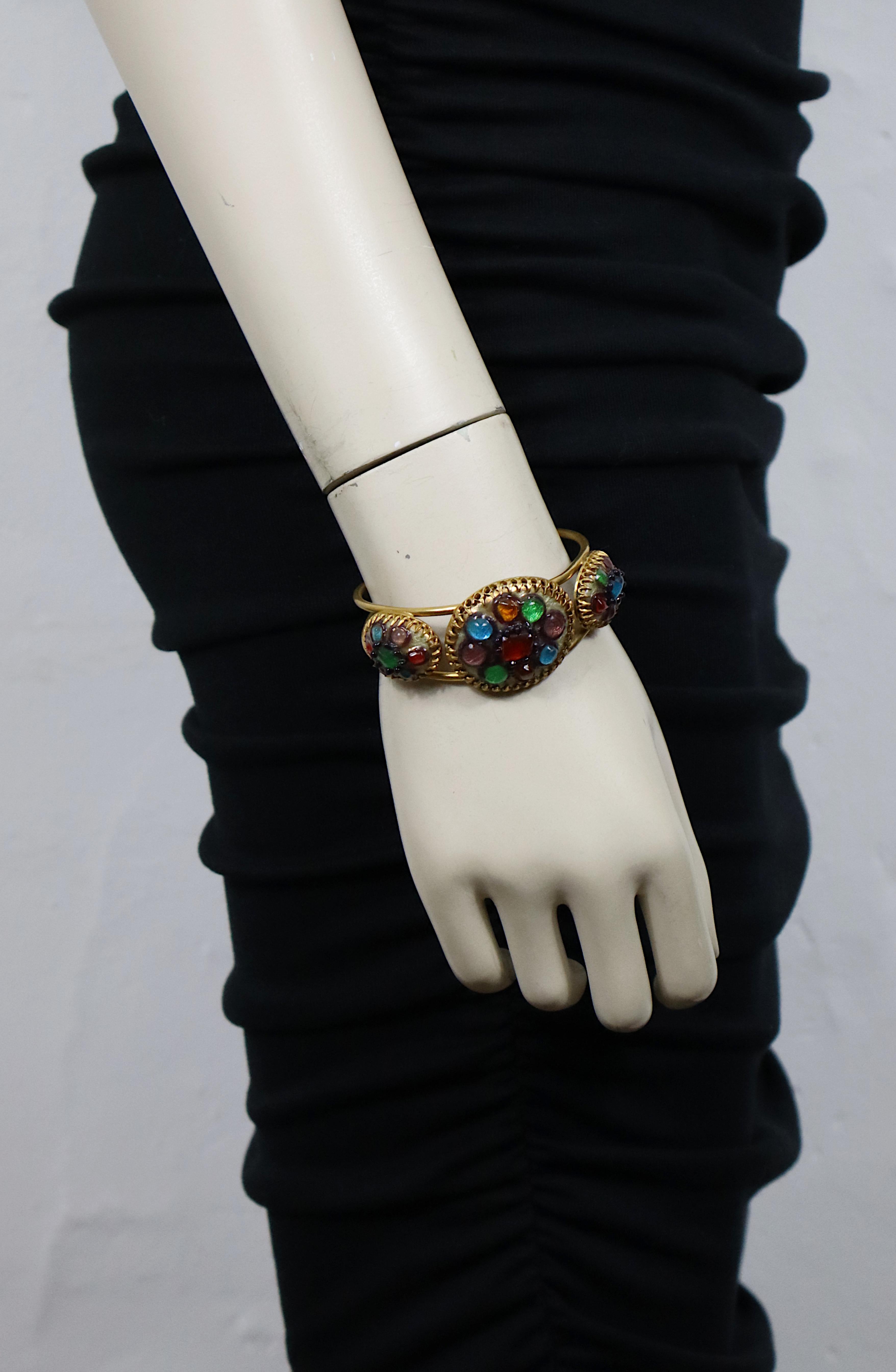 ANDREE BAZOT bracelet bangle rigide vintage en ton or agrémenté de trois cabochons en verre émaillé et coulé multicolores.

Marqué ANDREE BAZOT Paris.

Mesures indicatives : circonférence intérieure environ 17,91 cm (7,05 pouces) / largeur max.