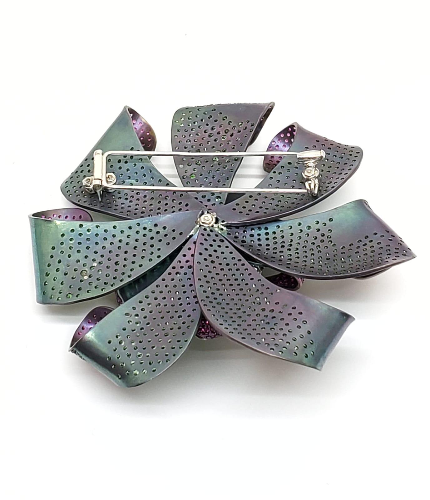 Broche fleur en titane et diamant Andreoli Colombian Emerald Pink Sapphire Tsavorite. Andreoli a été l'un des premiers créateurs de bijoux à utiliser le titane en haute joaillerie par rapport au 18KT ou au platine. L'utilisation du titane permet de