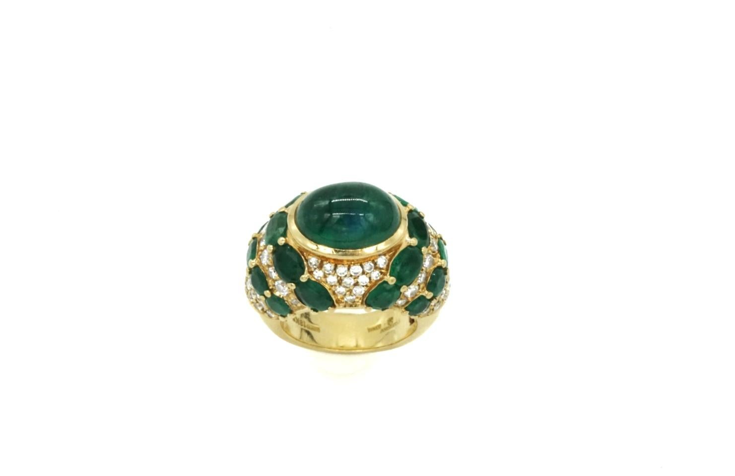 An Emerald and diamond bombe cocktail ring by Andreoli in 18k yellow gold. Made in Italy, circa 1970. The main cabochon emerald is approximately 5-6 carats. And the surrounding emeralds total approximately 4-5 carats. The diamonds total
