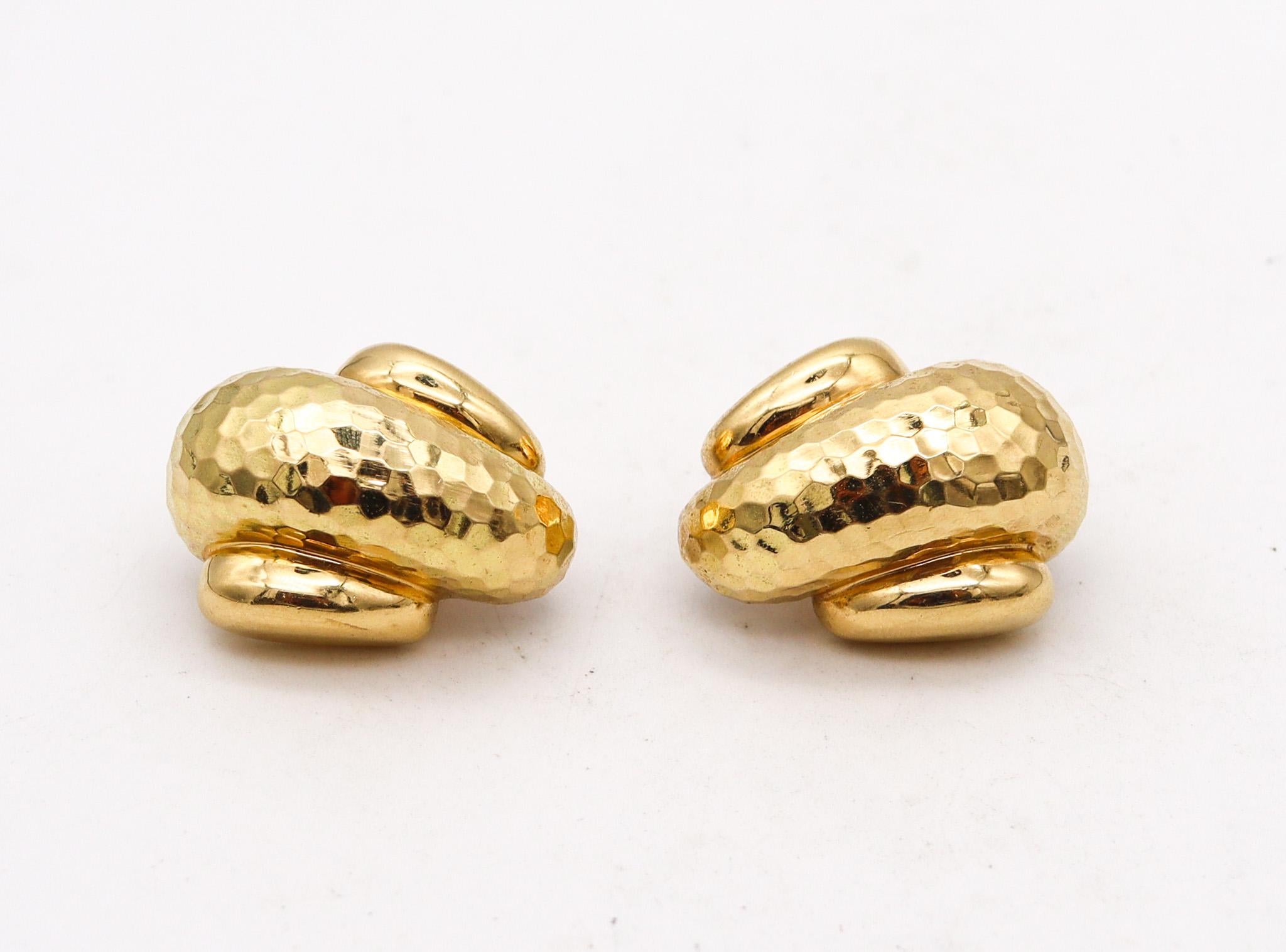 Boucles d'oreilles à pince conçues par Andrew Clunn.

Cette paire de boucles d'oreilles a été créée à New York dans l'atelier de joaillerie d'Andrew &New. Ces boucles d'oreilles ont été fabriquées avec des motifs martelés en or jaune riche et massif