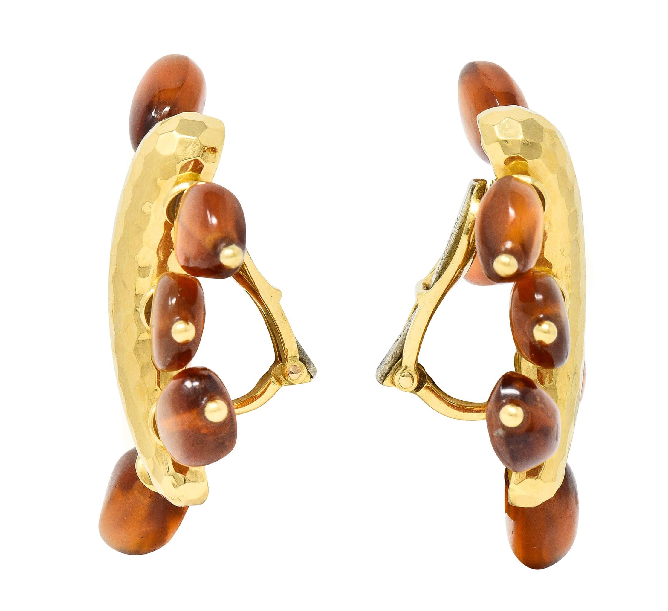 Comprised of hammered teardrop-shaped gold forms with fanning citrine beads
Beads are tumbled and organically shaped - ranging in size from 7.5 to 12.0 mm
Transparent medium brownish orange in color - with beaded gold terminals
With high polish
