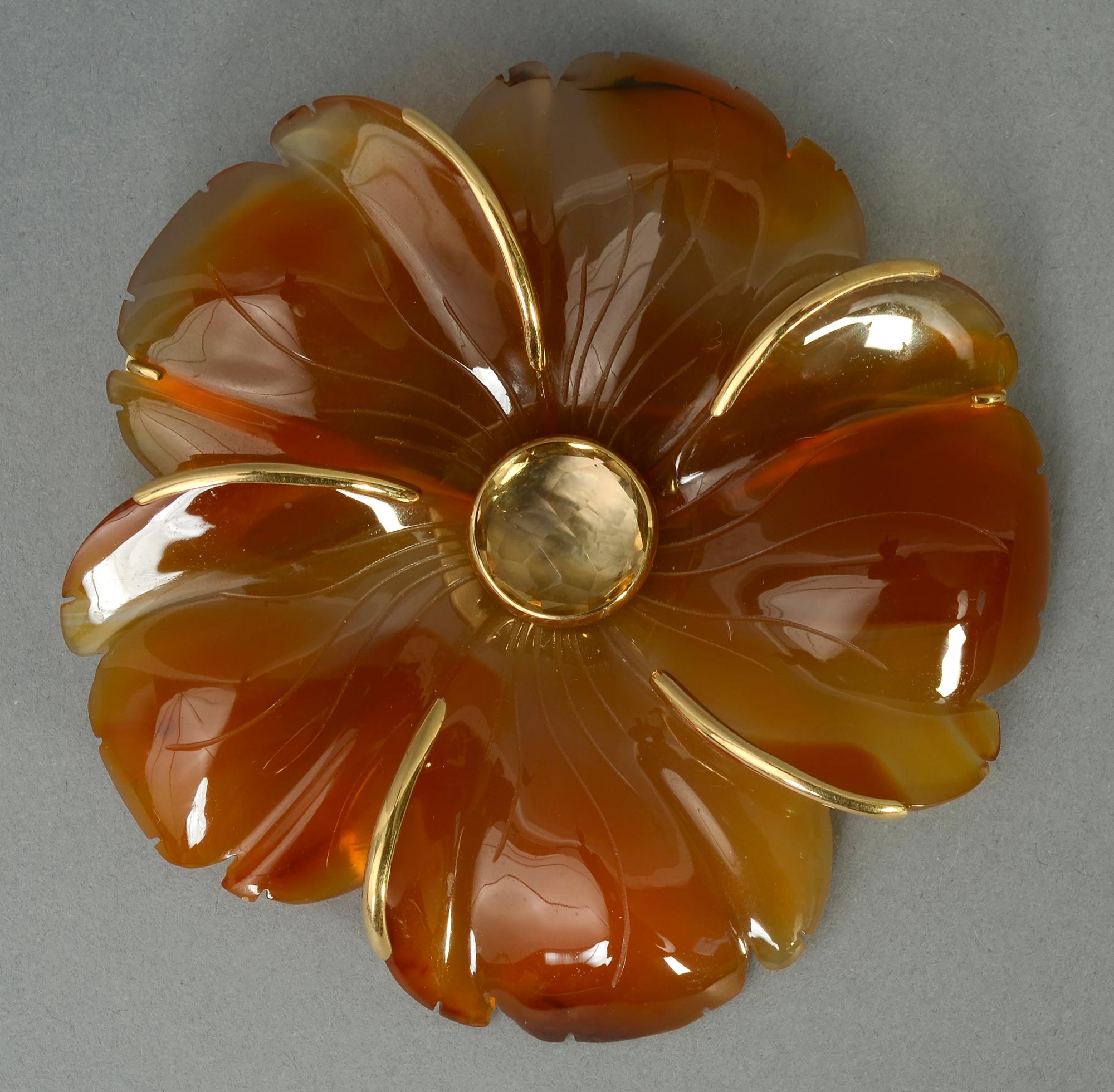 Beautifully carved flower brooch of agate centered with citrine by the late American jewelry designer, Andrew Clunn.
This very three dimensional brooch is carved from one piece of stone. Gold banding highlights the five petals.
This brooch is one of
