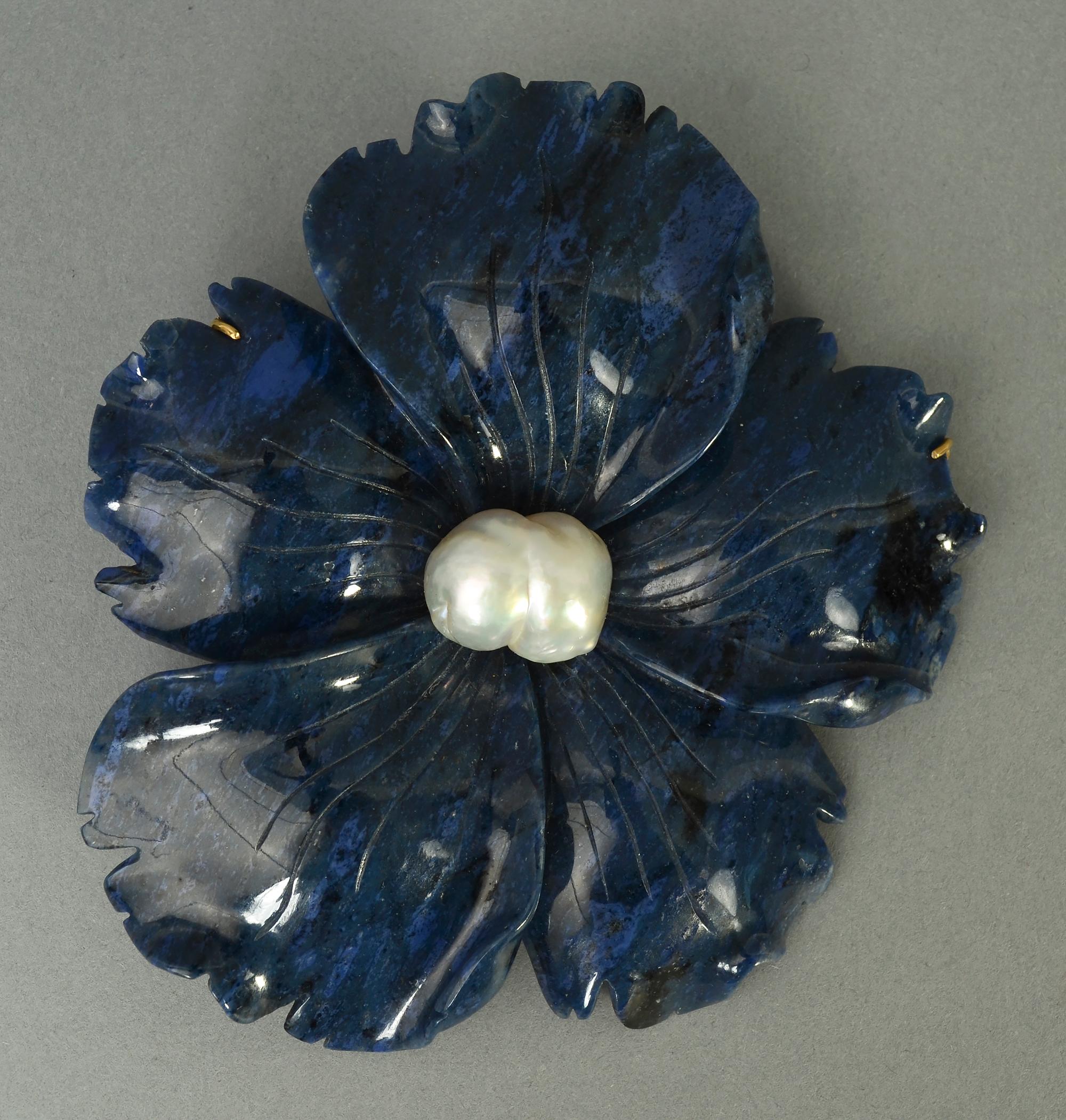 Este broche de flor tallada en lapislázuli de Andrew Clunn es tanto una pieza de escultura como una joya. Está bellamente tallada, con bordes ondulados y doblados y una calidad totalmente escultural. Toda la pieza está tallada en una sola pieza de