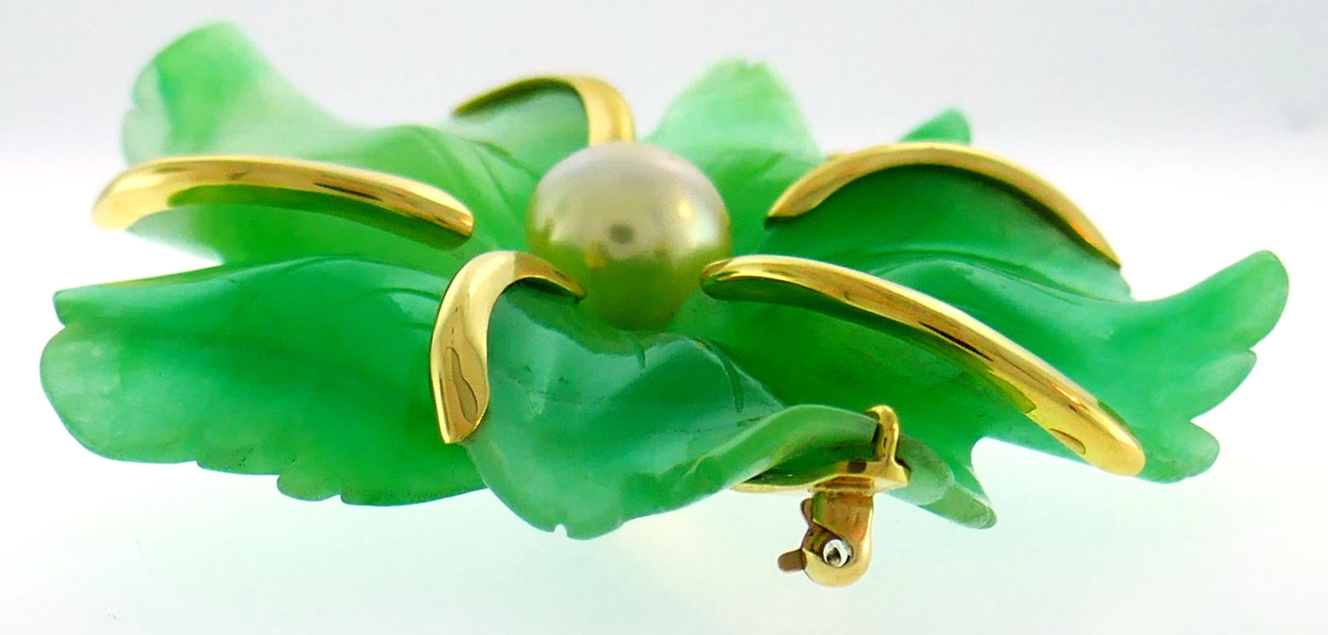 Bold and elegant pin created by Andrew Clunn in the 1980s. Colorful, chic and wearable, the clip is a great addition to your jewelry collection. 
Made of 18 karat (stamped) yellow gold and carved chrysoprase accented with a South Sea golden
