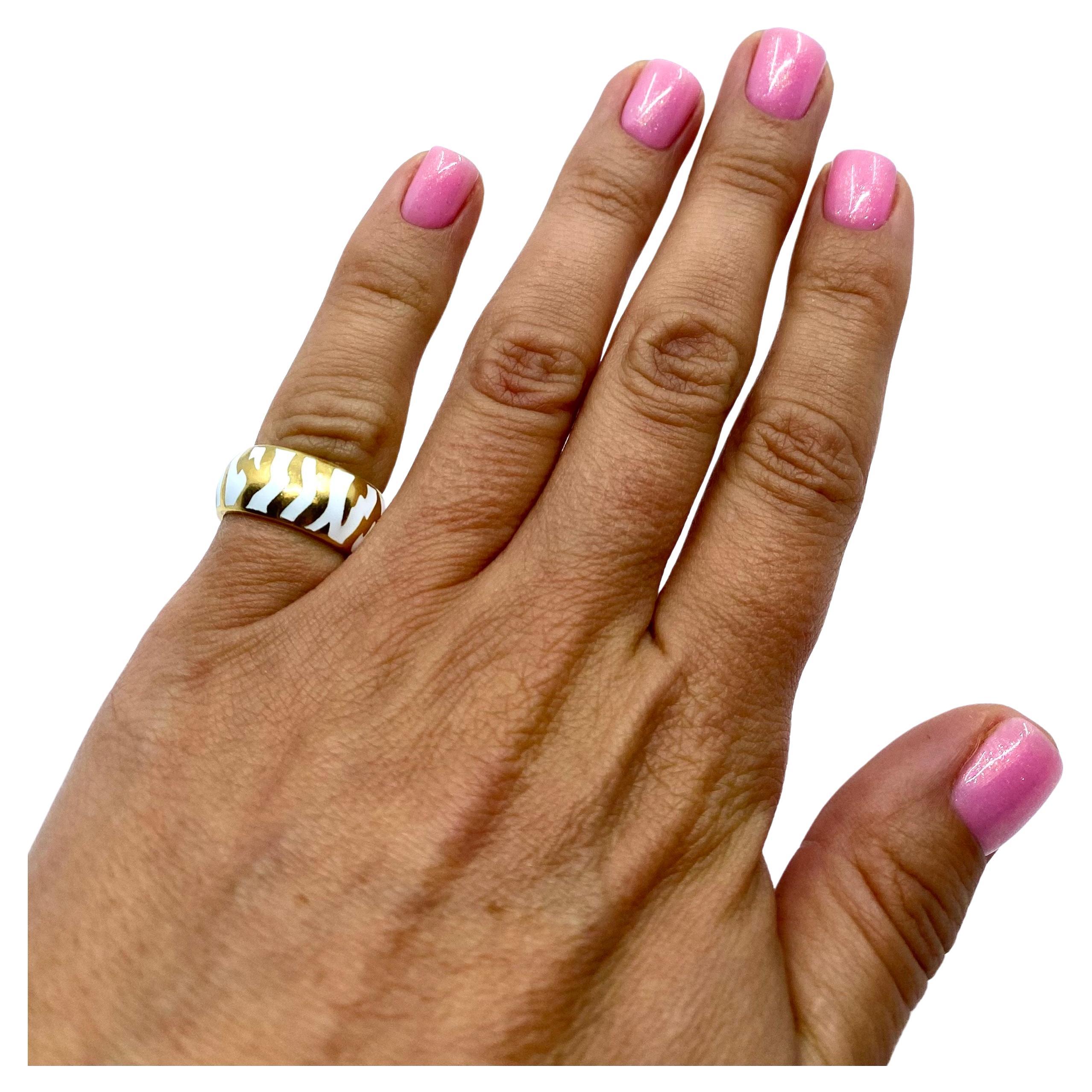 A fun vintage ring by Andrew Clunn, made of 18k gold and white enamel. In this ring was used a zebra pattern by applying white enamel on the yellow gold background. The pattern along with the puffed shape of the band creates a unique, undeniably