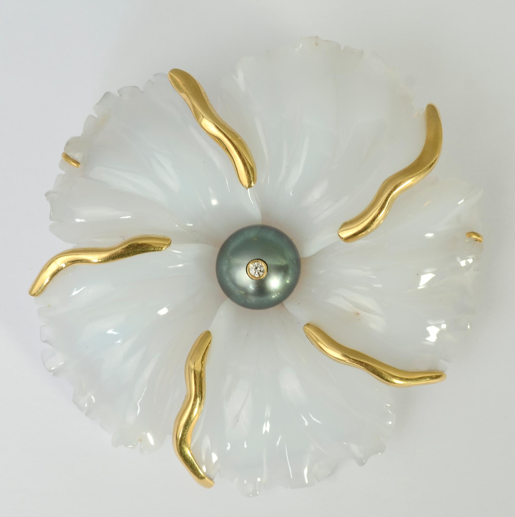 This carved flower brooch of white agate by Andrew Clunn is as much a piece of sculpture as a piece of jewelry. It is beautifully carved with ruffled and folded edges and a totally sculptural quality. The entire piece is carved from one piece of