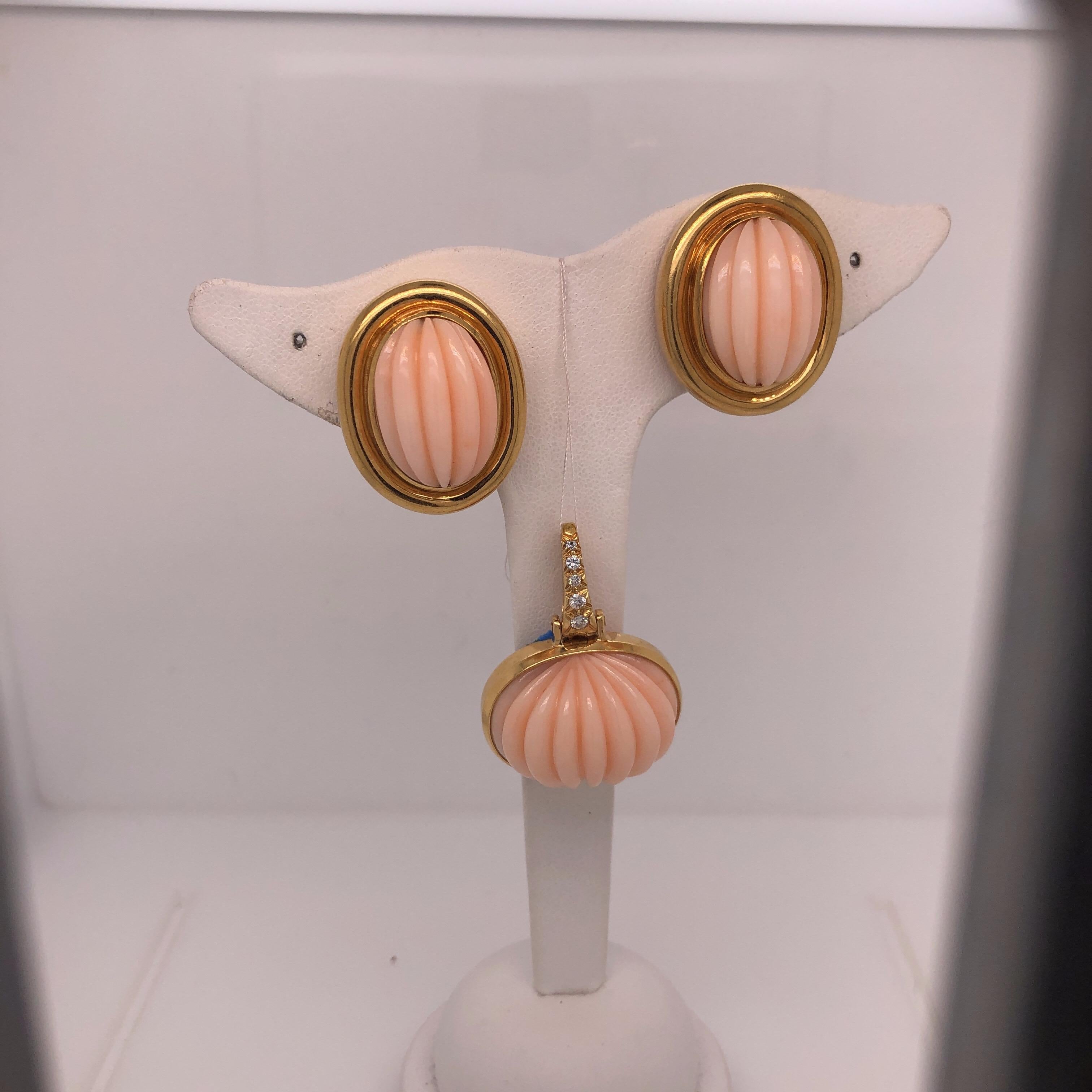 Beautiful Carved Coral Set from Acclaimed Designer Andrew Clunn who worked extensively with David Webb.  The set includes a pair of Carved Coral Earrings set in 18K Yellow Gold.  All pieces stamped A Clunn and 18K.  The pendant features a matching