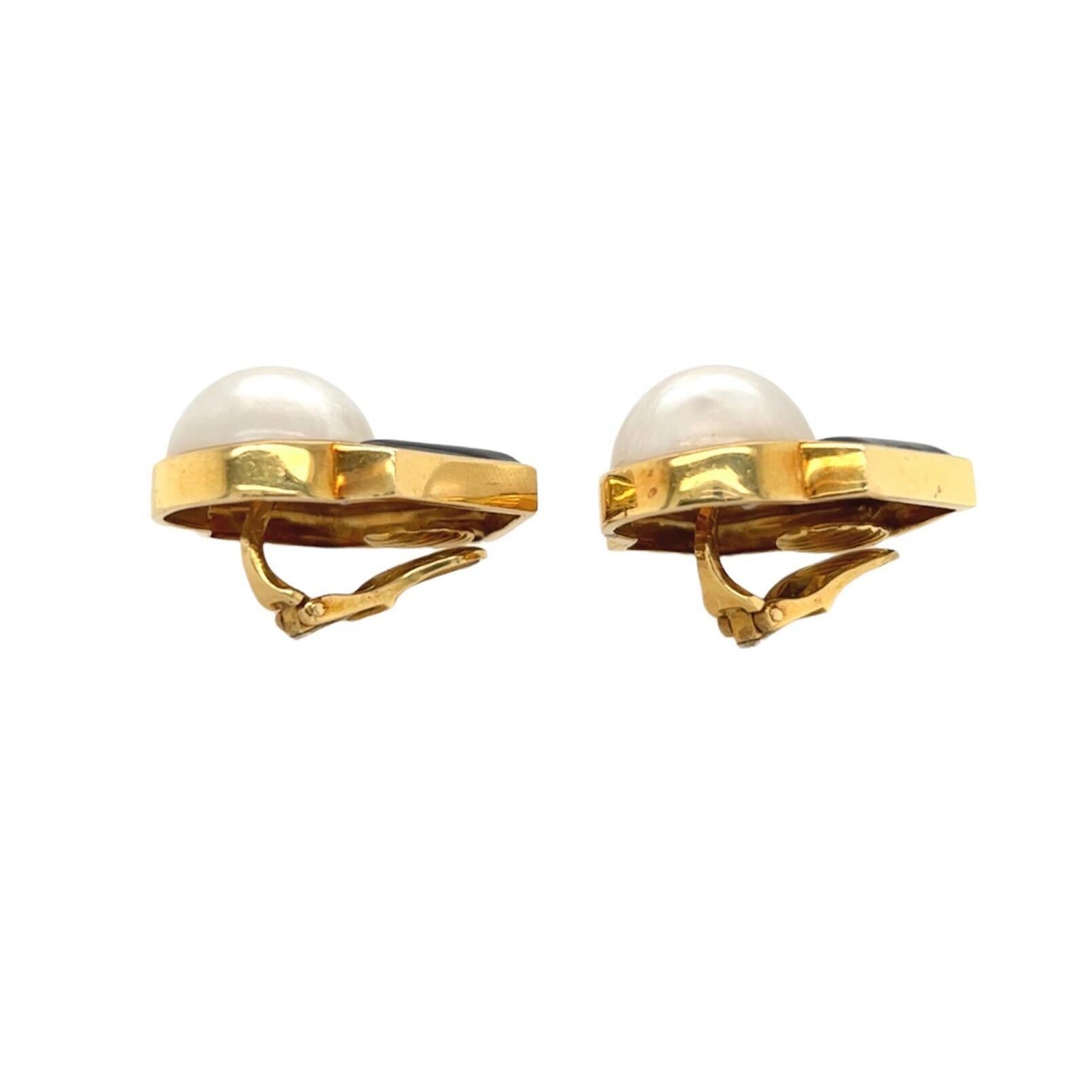 A pair of 18 karat yellow gold, mabe pearl, diamond and enamel earclips. Andrew Clunn.  Designed as geometric plaques centering a mabe pearl surmounted by pave diamonds in a black enamel frame.  Nineteen diamonds in each earring total thirty eight