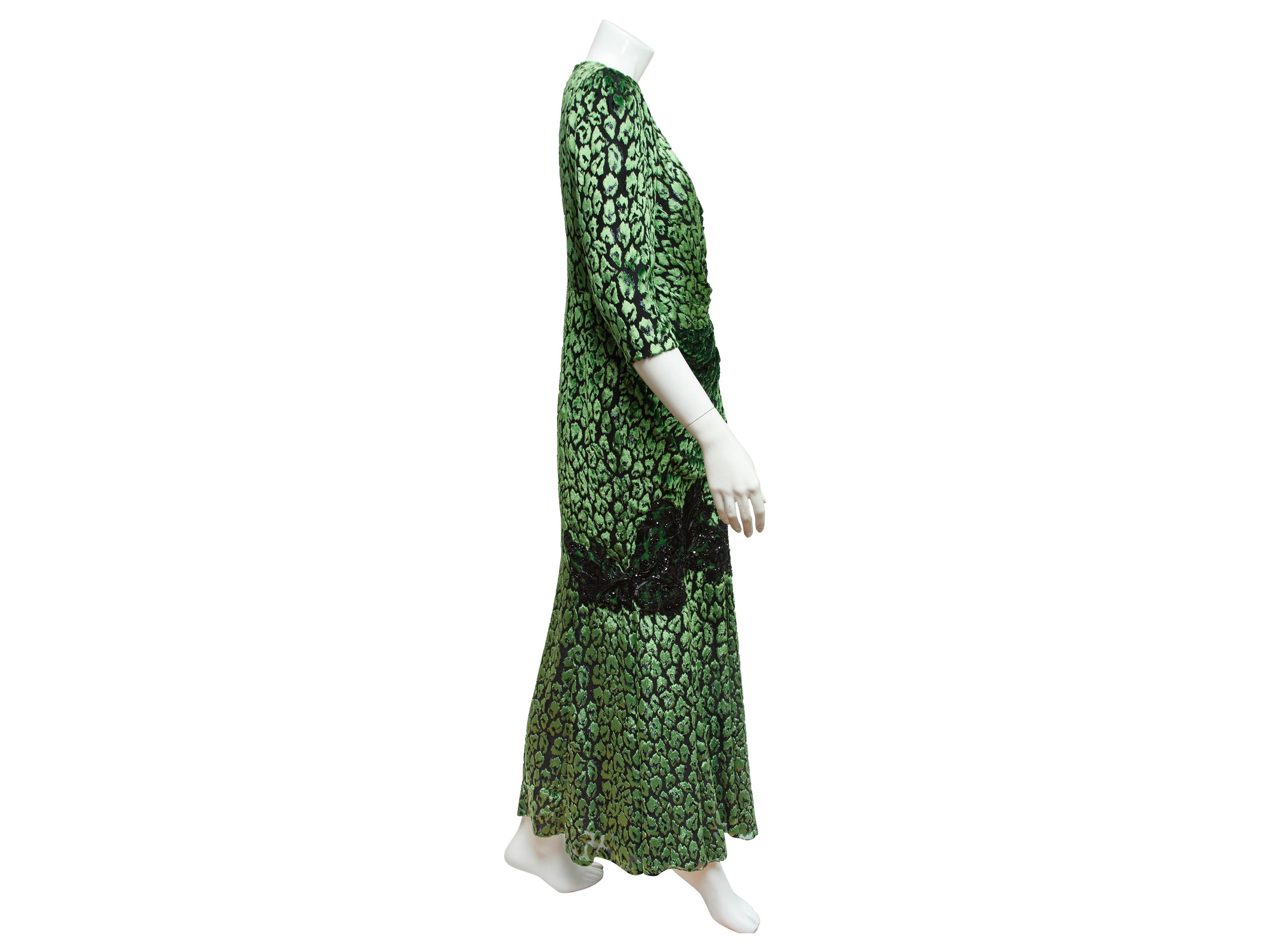 Product details:  Metallic green animal-print gown by Andrew Gn.  Accented with black beaded lace panels.  V-neck.  Elbow-length sleeves.  Surplice bodice.  Concealed back zip closure.  38
