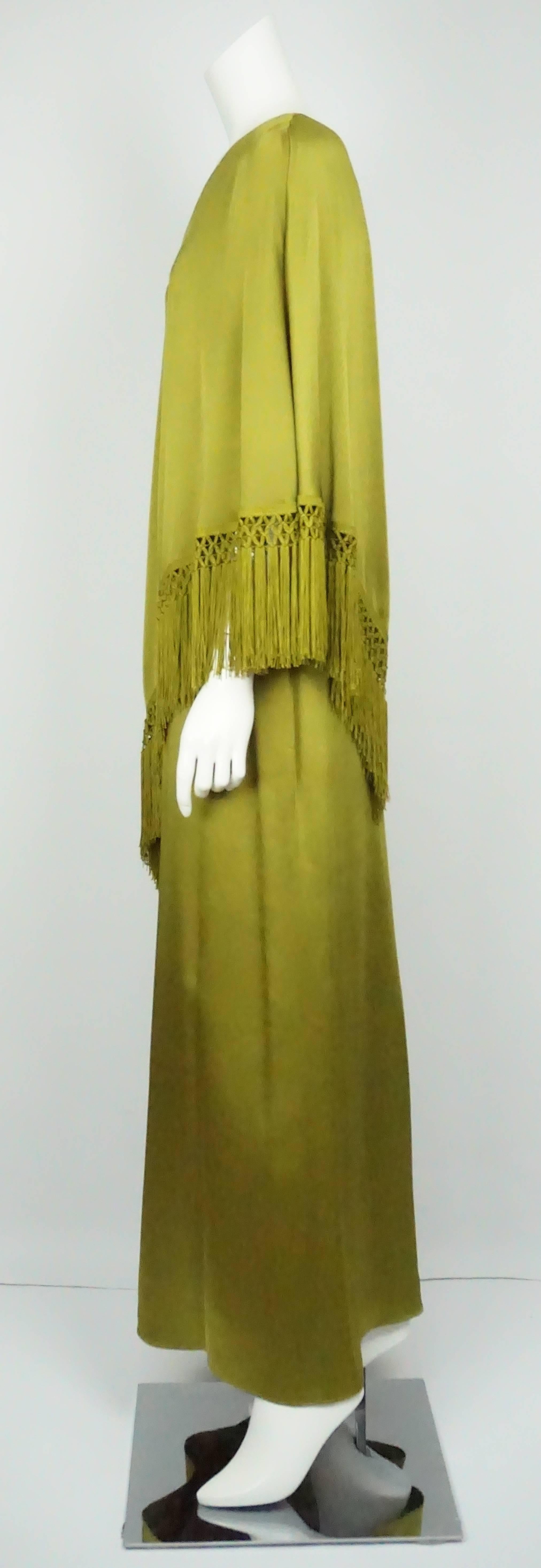 Andrew Gn Olive Green Silk One Shoulder Gown w/ Fringe - 40 This dramatic yet beautiful Andrew Gn dress is silk with a one shoulder poncho like top with fringe. There is a back zip with a unique woven detailing and it is floor length. 
Measurements:
