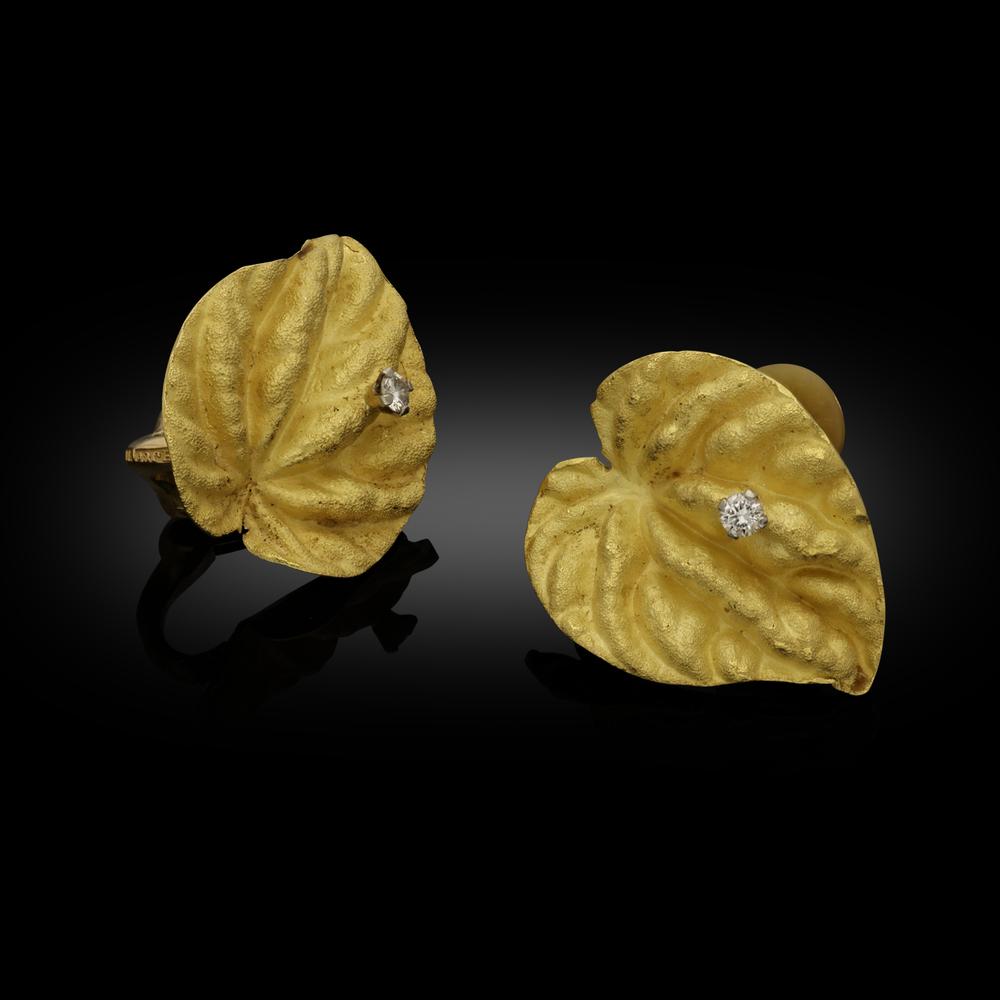 A pair of gold and diamond leaf earrings by Andrew Grima 1967, the earrings cast in 18ct yellow gold from two leaves of a cyclamen plant, the heart shaped leaves with undulating heavily textured surface have been given a sandblasted matte finish,
