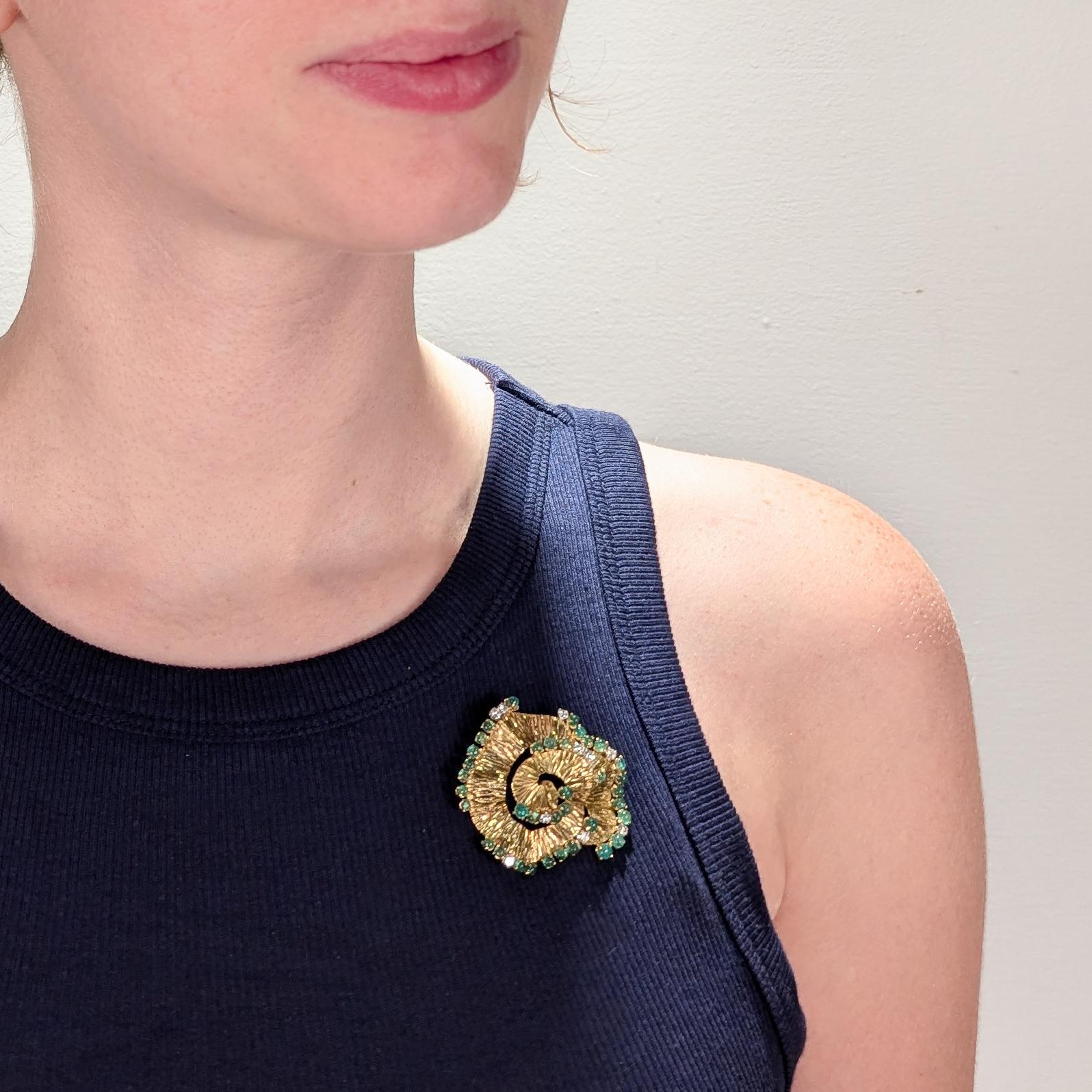 Una raffinata spilla modernista in oro 18 carati, smeraldi e diamanti.

Attribuito a Andrew Grima. 

Comprende una spirale strutturata in oro giallo 18 carati con smeraldi tondi lisci incastonati e diamanti tondi brillanti sul bordo della spirale.