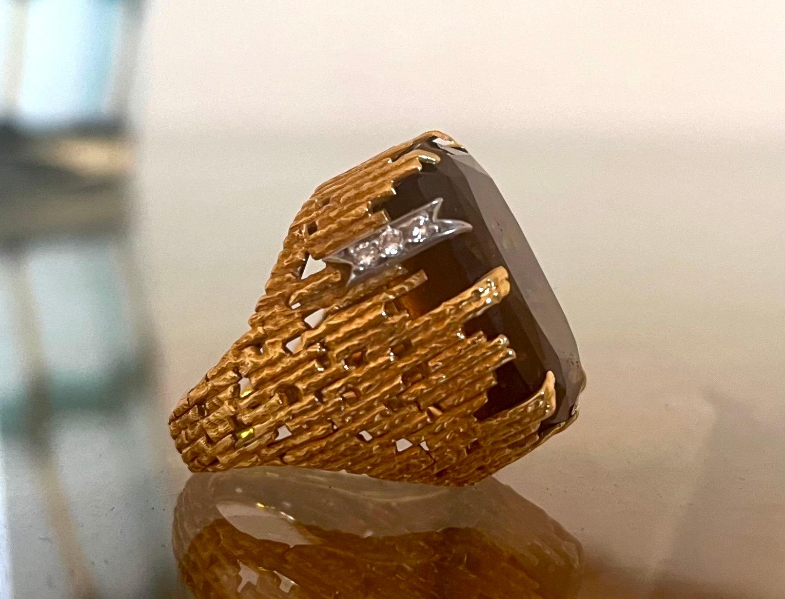 Iconic Modernist Ring by Andrew Grima.

20 carats Cushion Cut Brown Quartz in a 18K Gold textured graphic setting; Signed Grima

Andrew Grima (31 May 1921 – 26 December 2007) was an Anglo-Italian designer who became known as the doyen of modern