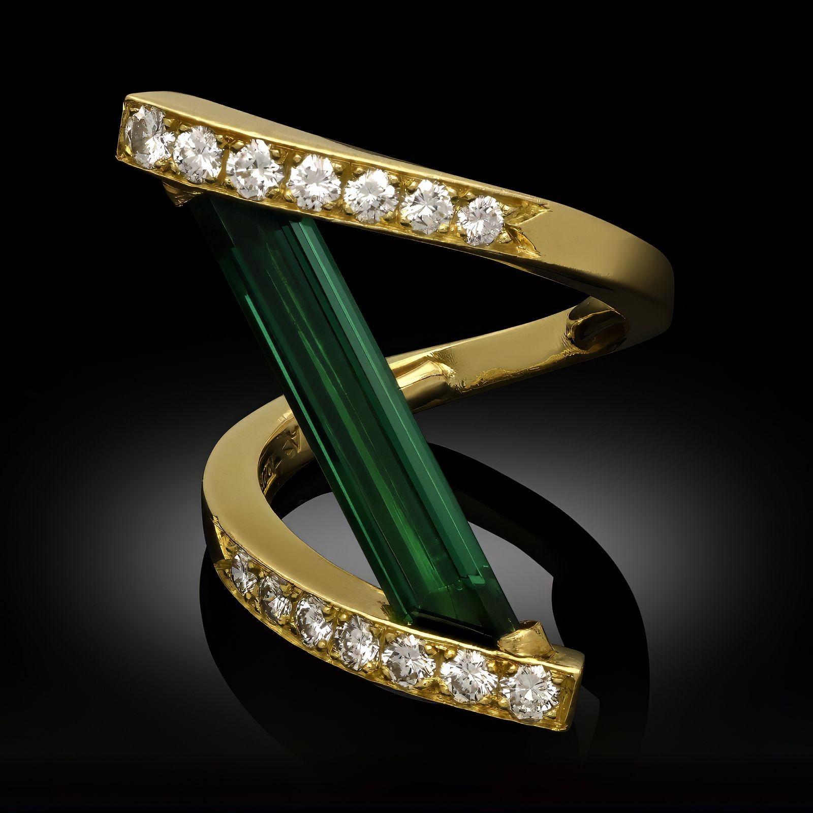 Anillo vintage de turmalina verde y diamantes de Andrew Grima, 1972. Anillo de diseño cruzado, con una sola turmalina verde de talla escalonada engastada verticalmente en el centro y engarzada a ambos extremos en un diseño cruzado de oro amarillo de