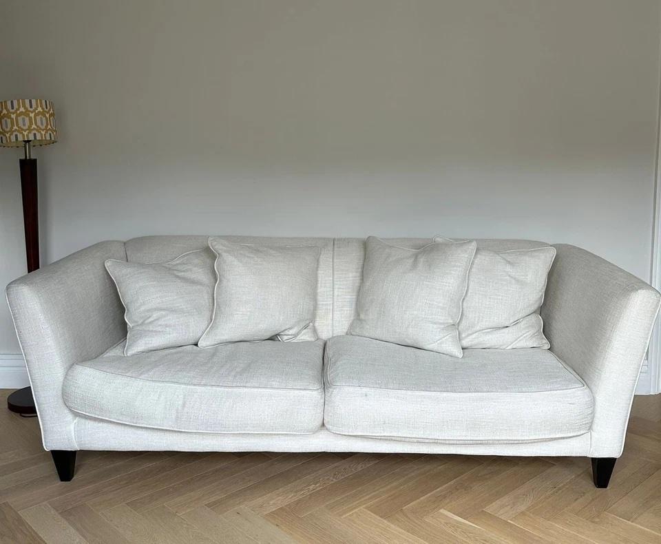 A beautifully crafted custom 4-seater ‘Hannis’ sofa by Andrew Martin, upholstered in the luxurious Rocco Hazy Sky fabric, a soft, textured weave in a calming off white / cream tone that adds  elegance to any living space.

This generously