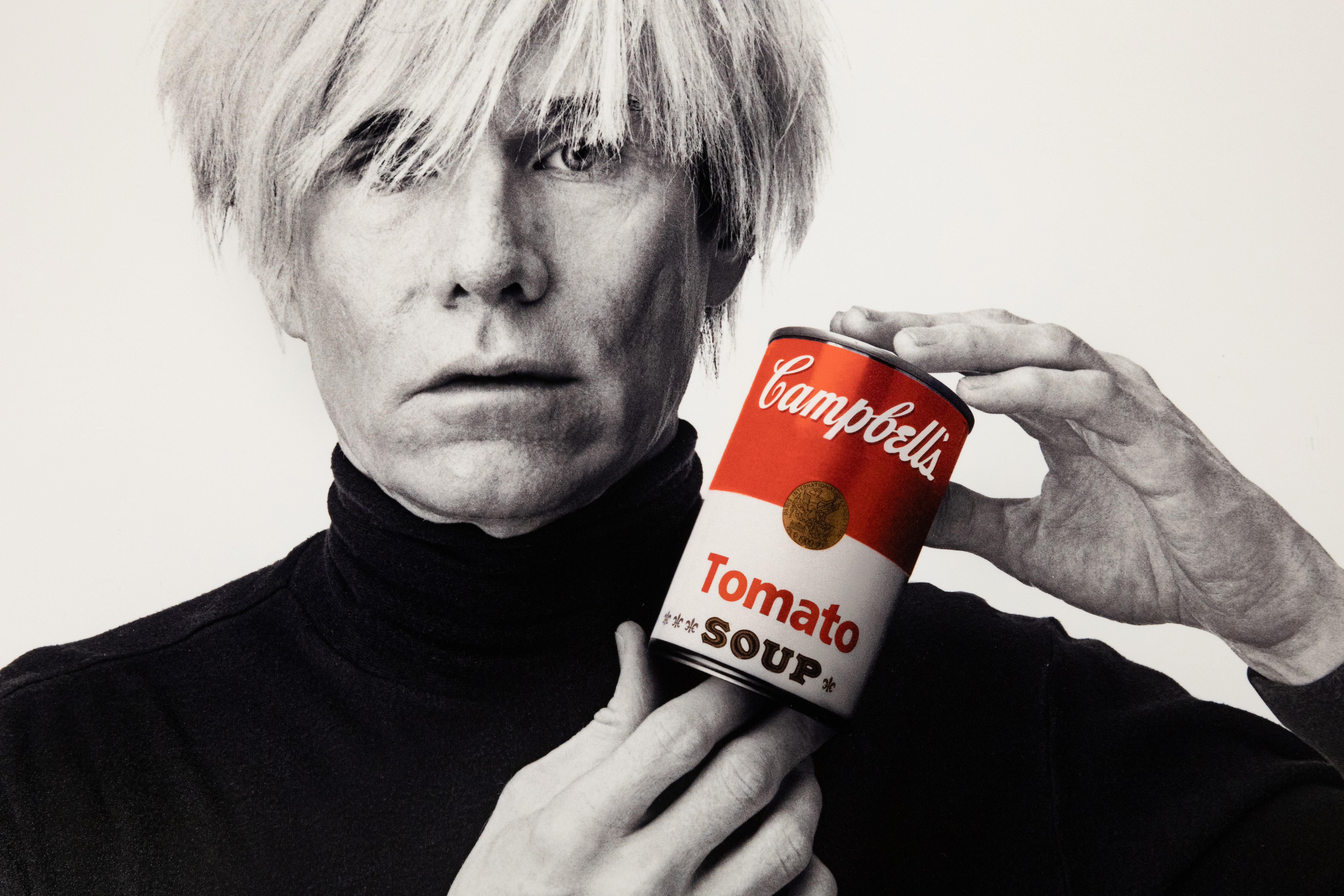 Archiv-Fotodruck 'Andy Warhol mit roter Campbell's Suppe' 1985/2025 (Beige), Portrait Photograph, von Andrew Unangst