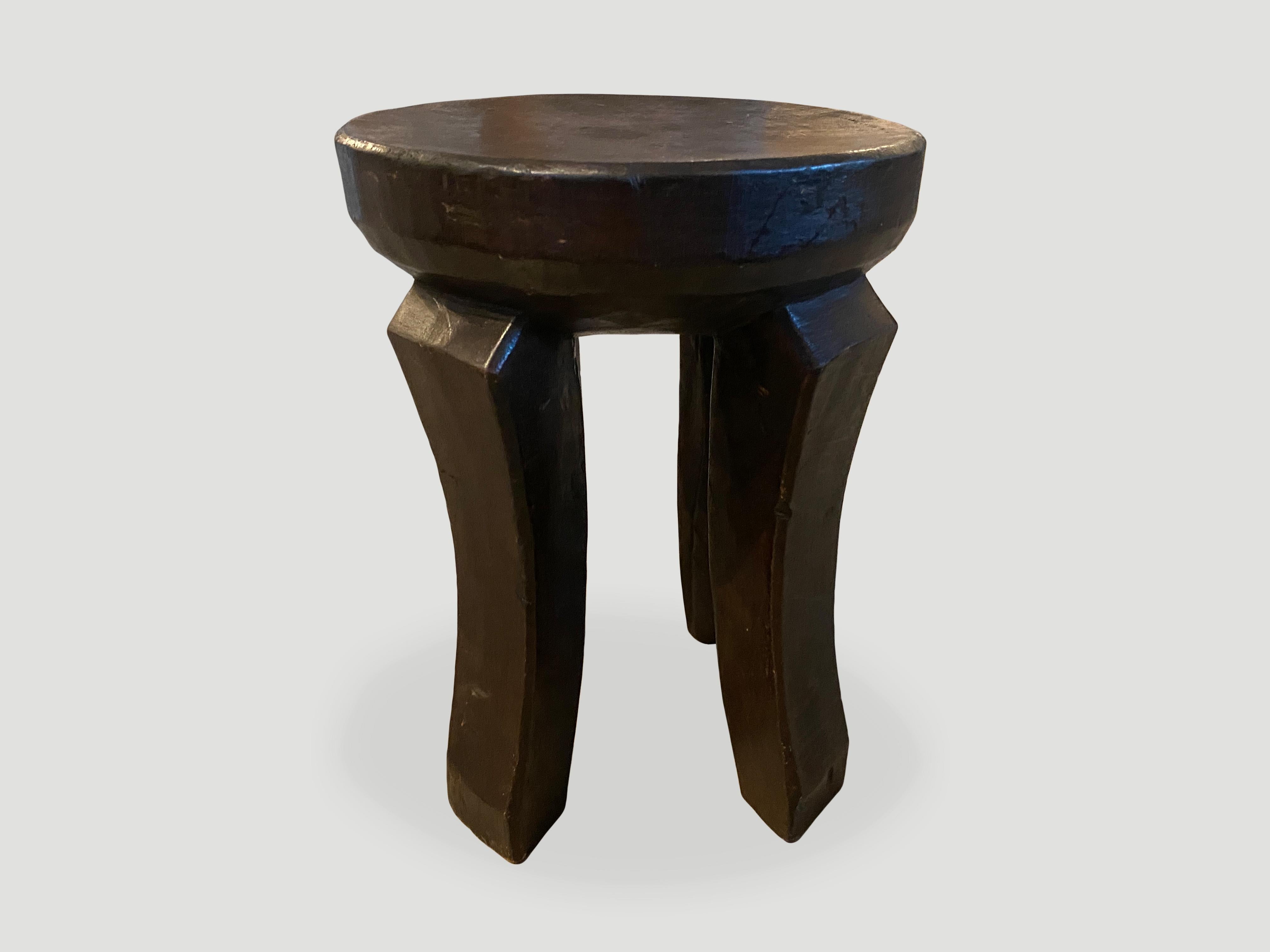 Antique African side table or stool hand carved from a single block of mahogany wood. The top is a thick bevel with beautiful hand carved legs. These stools have become collectable in recent years. We only source the best. We have a pair. The price