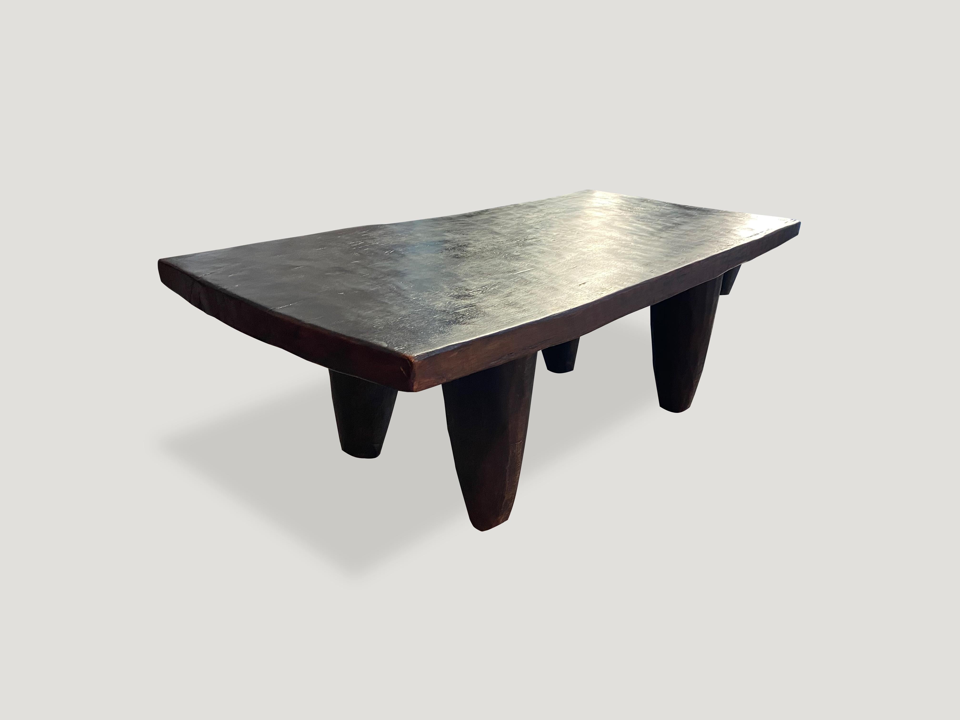 Antique coffee table or bench carved from a single piece of iroko wood, made by the Senufo Tribe from the Ivory Coast. The wood is tough, dense and very durable. A single two inch thick slab coffee table or bench with cone style legs.

This coffee