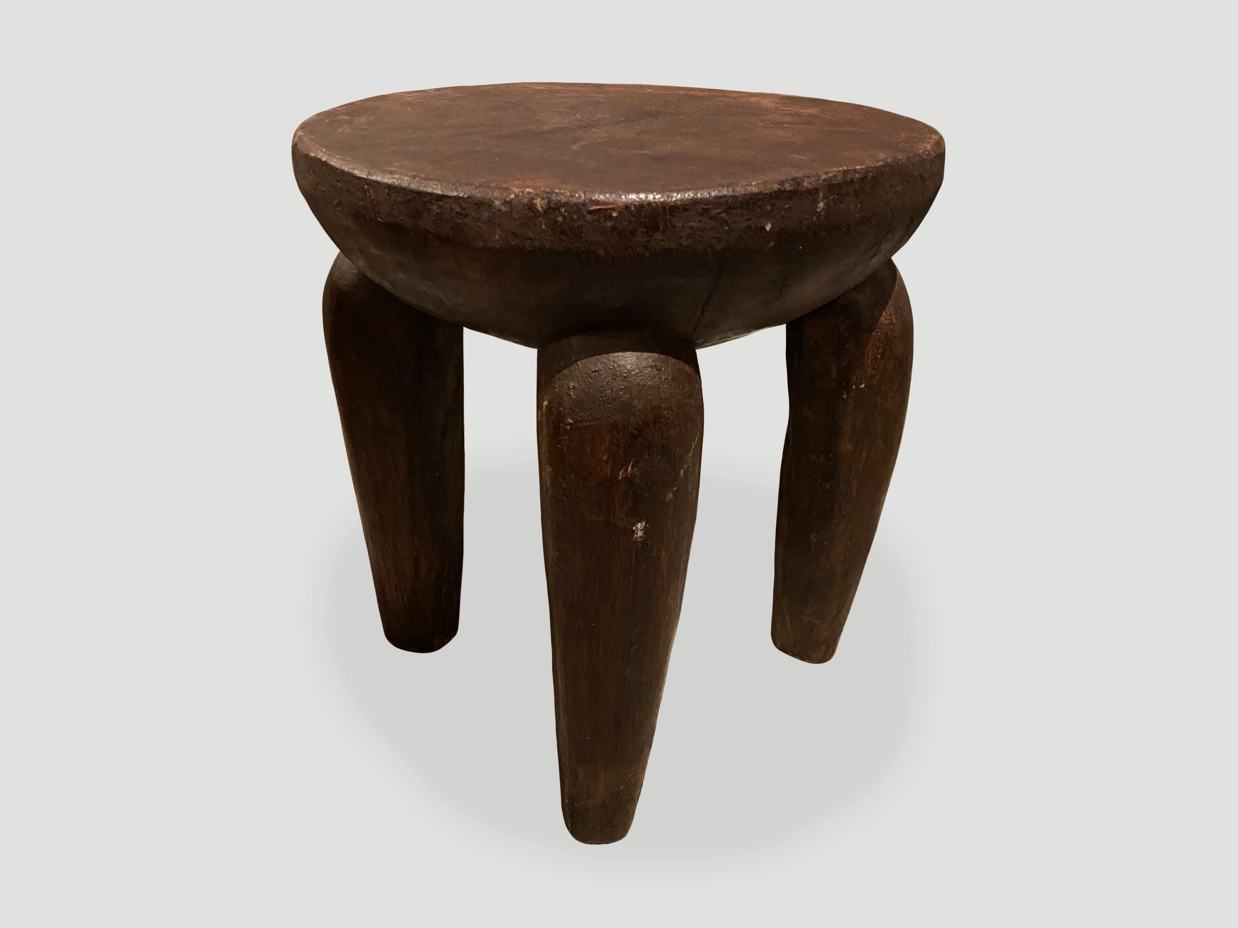 Antique African side table or stool hand carved from a single block of mahogany wood. The top is a thick bevel with beautiful hand carved legs and lovely patina. We only source the best.

This side table or stool was sourced in the spirit of