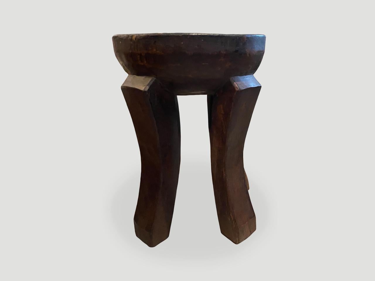 Table d'appoint ou tabouret africain antique sculpté à la main à partir d'un seul bloc de bois d'acajou. Le dessus est un épais biseau avec de beaux pieds sculptés à la main et une belle patine. Ces tabourets sont devenus des objets de collection