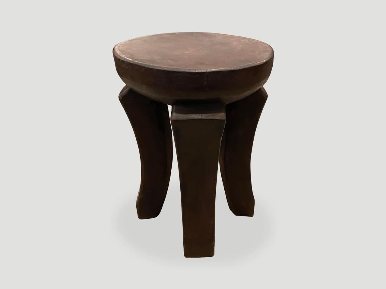 Antique African side table or stool hand carved from a single block of mahogany wood. The top is a thick bevel with beautiful hand carved legs. We only source the best. We have a pair. The price and images reflect the one shown.

This side table