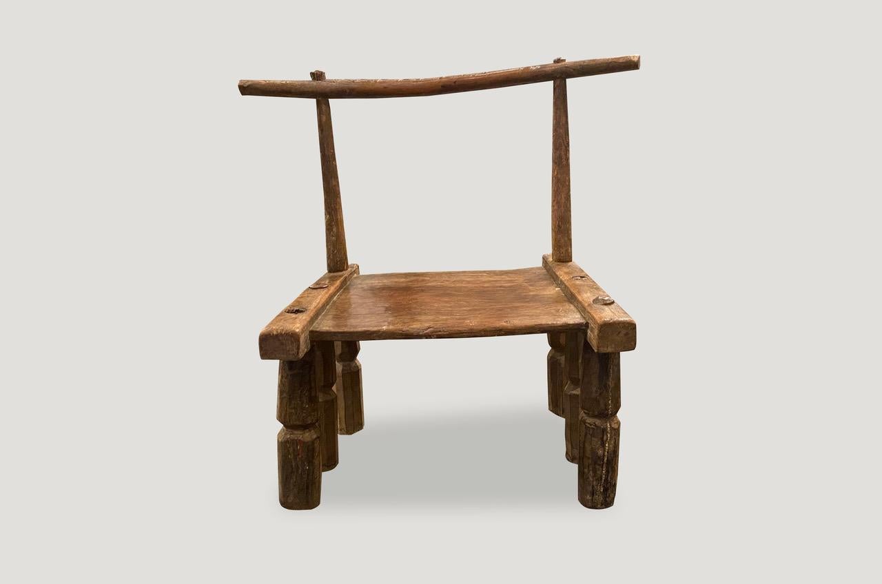 Preciosa pátina en esta silla de madera tallada a mano del siglo XIX, procedente de la Costa de Marfil de África. Raro con 6 patas biseladas talladas a mano y motivo en el respaldo. También puede utilizarse como mesa auxiliar baja. Una obra de arte.